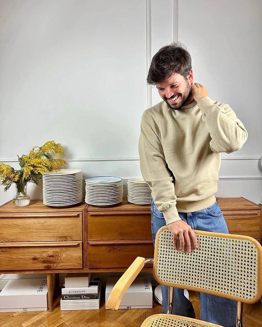 A table with various pastries, including a cake, croissants, and flans, is adorned with lit candles in an ornate candelabra and flower arrangements. Champagne glasses are also present, creating an elegant, festive ambiance.