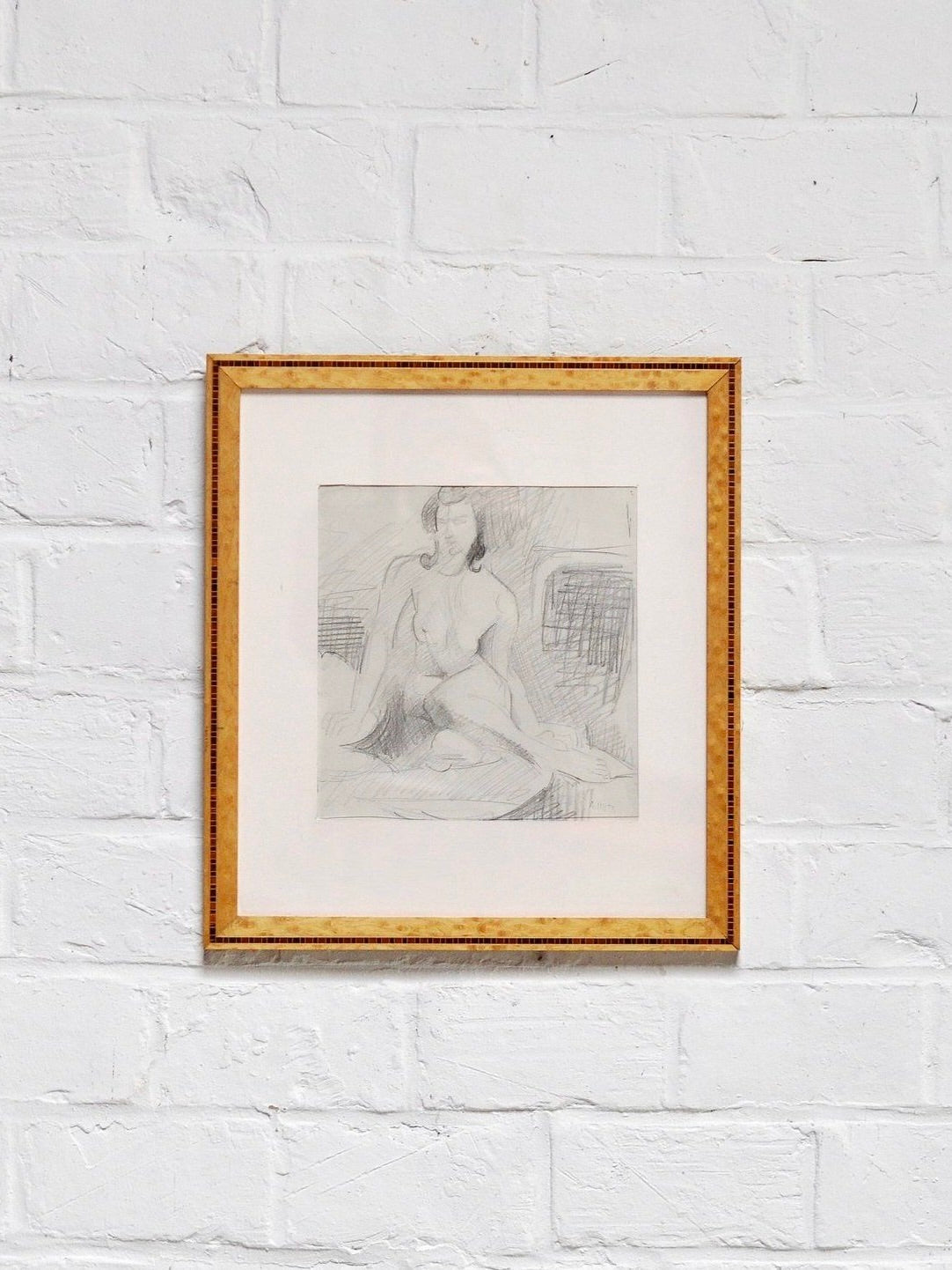Introverso offers "André Lhote (1885 - 1962) Drawing in Pencil," featuring a framed minimalist pencil sketch of a seated nude woman. The artwork captures soft lines and a relaxed pose, displayed within a simple wooden frame.