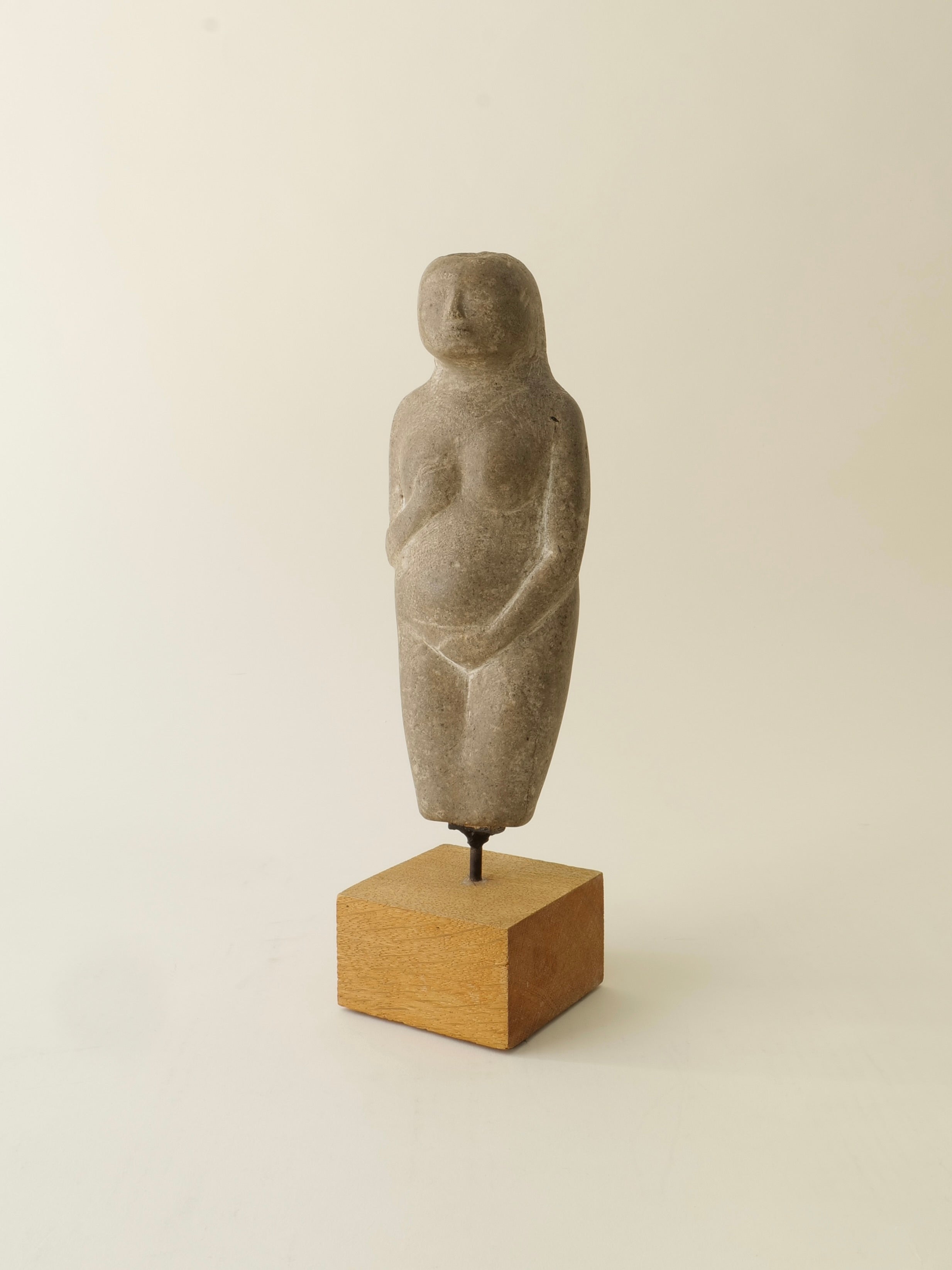 The Marble Figurine Sculpture by Håkan Bonds for Collection apart features a simple, abstract form with minimal details, standing upright on a wooden base against a plain, light background.