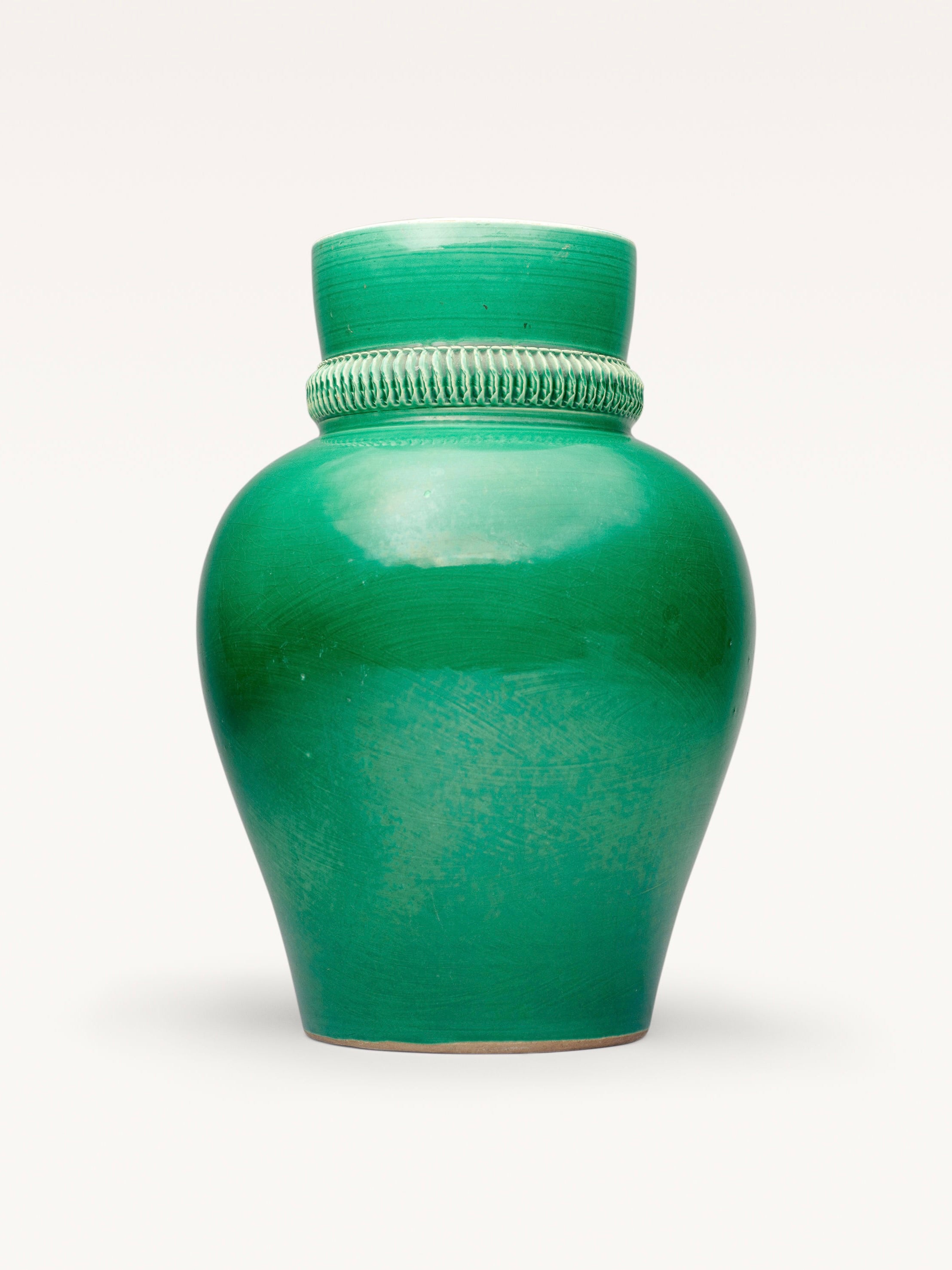 The Pol Chambost (1906 - 1983) Ceramic Vase by Galerie MLS features a glossy green finish with a rounded body. It also boasts a crackle glaze and intricate textured band on its narrow, slightly flared neck, all elegantly set against a plain, light background.