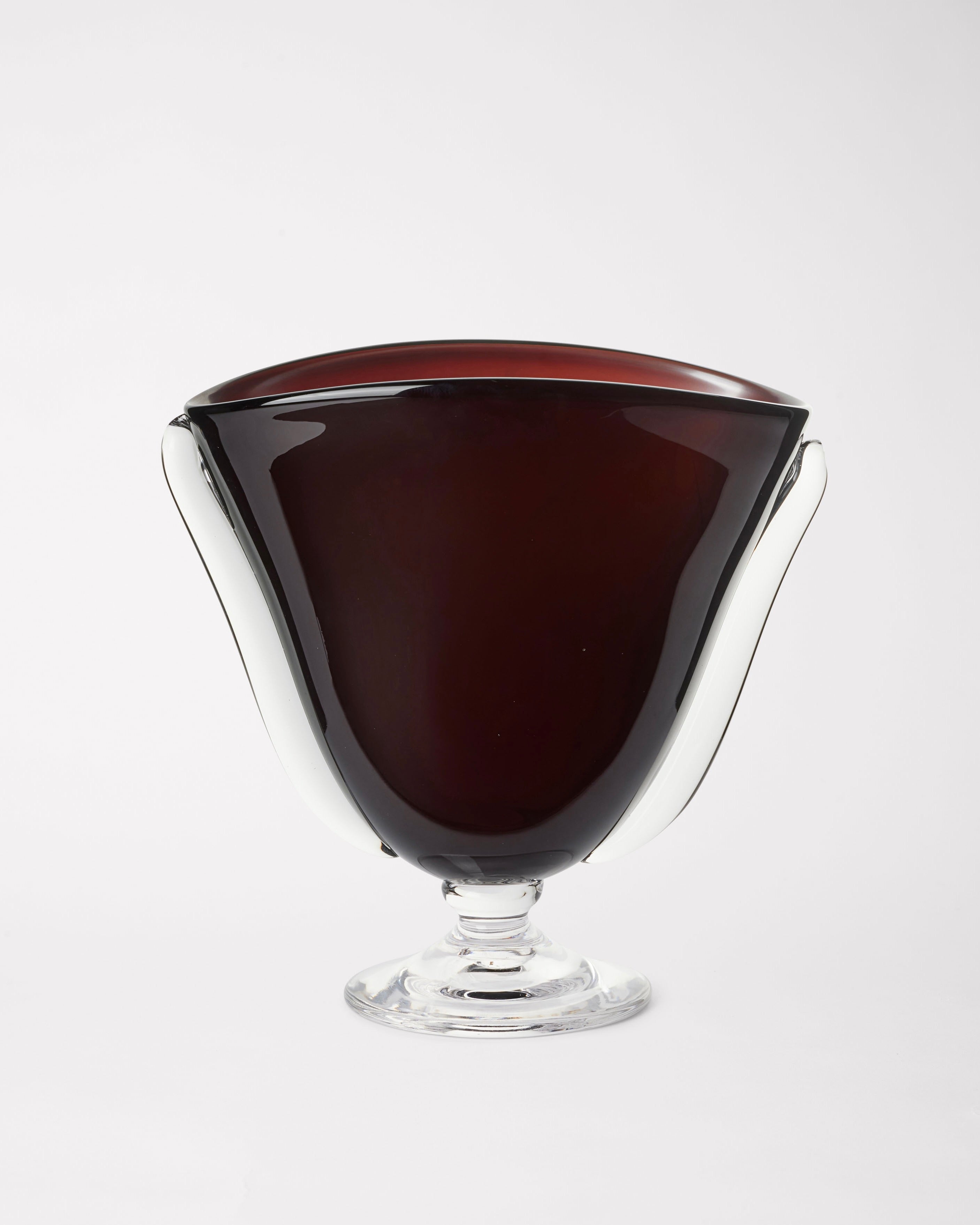 A deep red, elegantly shaped Mouth Blown Karl Vase by Akua Objects features a flared rim and clear base, crafted from Bohemian Glassware, set against a plain white background.