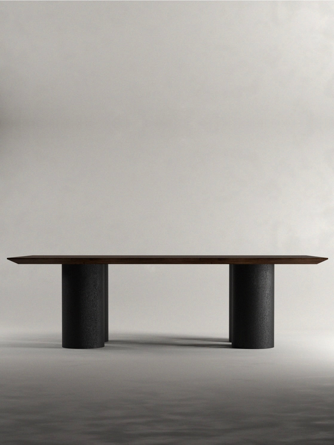 The 'Pier' Dining Table by Siete Studio showcases a slim walnut tabletop resting on two cylindrical black stone bases, set against a light gray background to enhance its modern elegance.