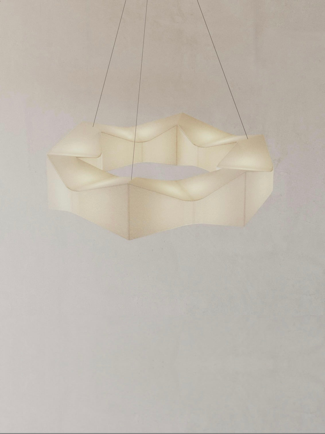 The "Arête" Pendant Circle by Asca Studio boasts a modern hexagonal design with a wavy, translucent look, suspended by three thin wires. This sophisticated piece beautifully illuminates against neutral walls, showcasing its sculptural elegance.