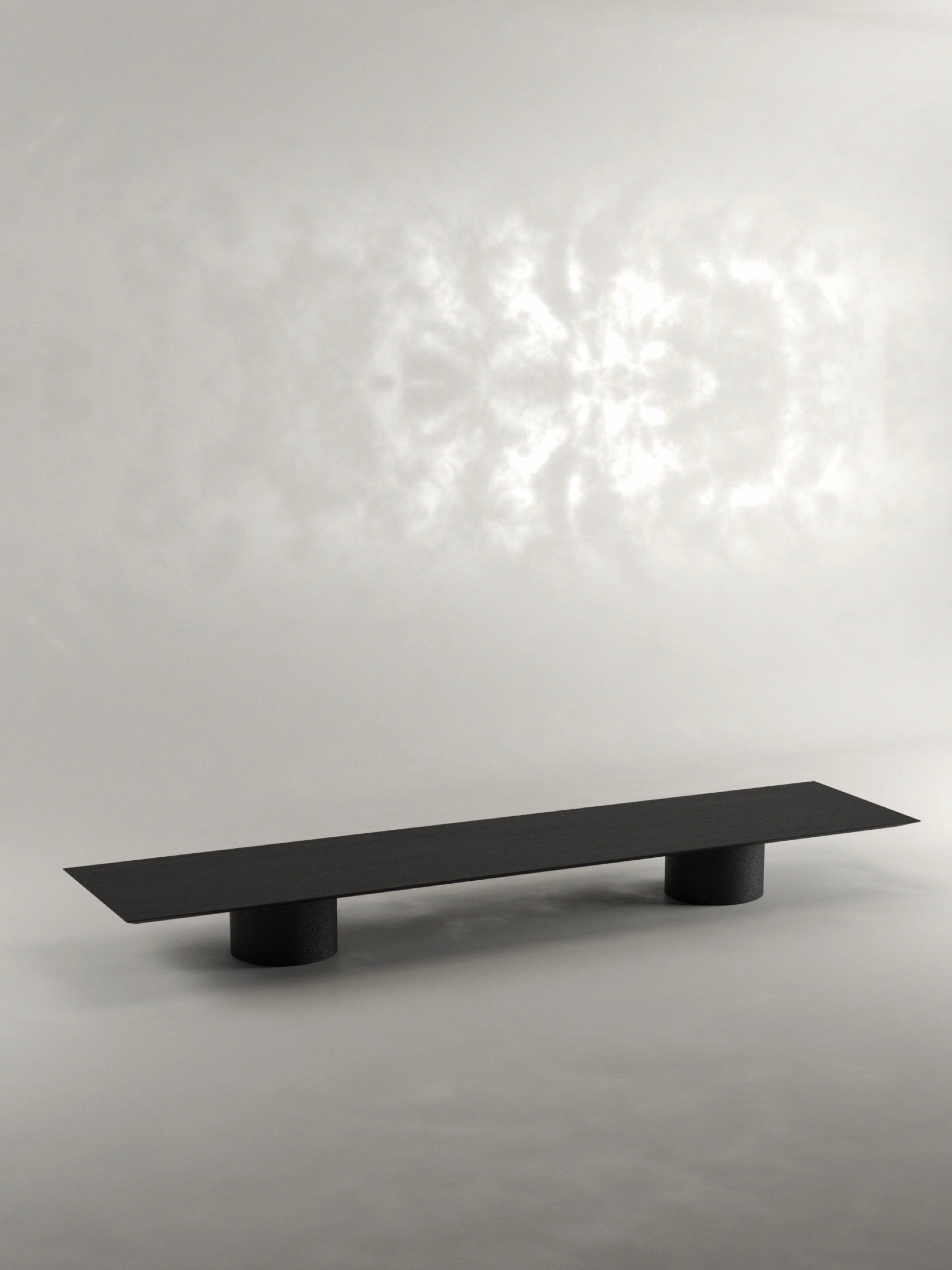 The 'Pier' Coffee Table by Siete Studio is a sleek, minimalist piece handcrafted from black oak with a flat, rectangular surface and two cylindrical legs, set elegantly against a neutral background.