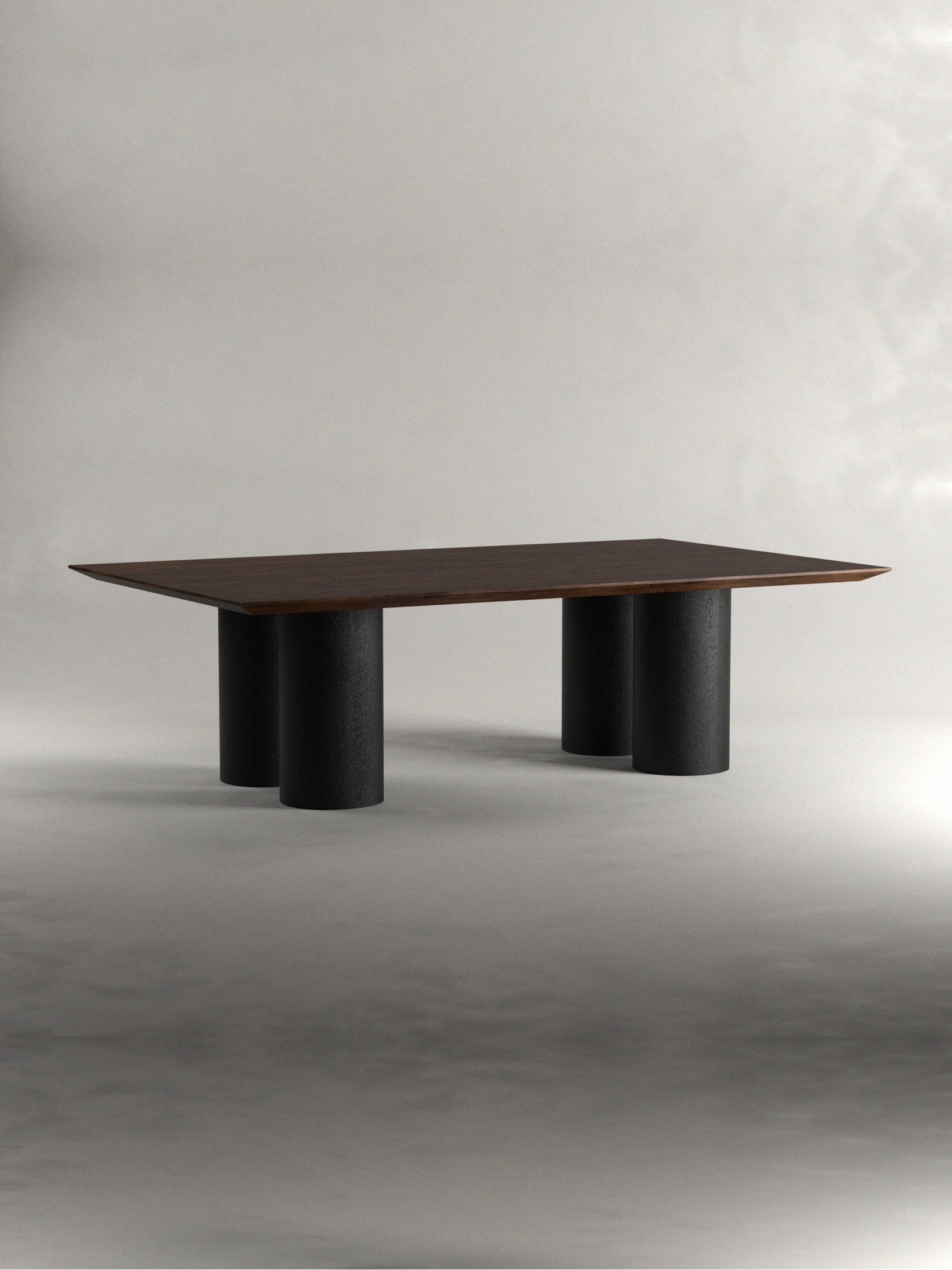 The 'Pier' Dining Table by Siete Studio features a modern rectangular design, a slim walnut tabletop, and four cylindrical black legs, set against a plain gray background.
