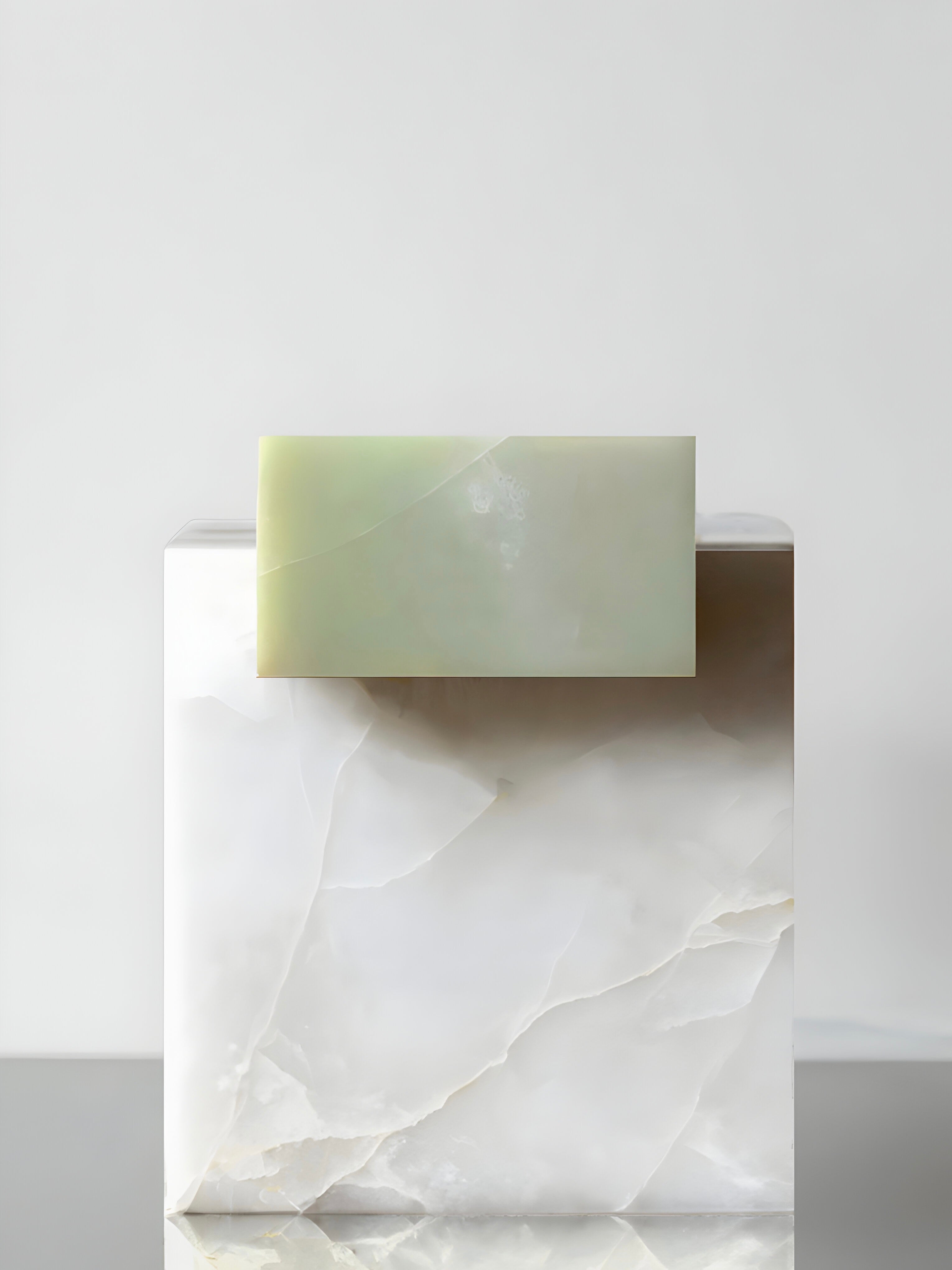 The Marbera Gaia White and Green Onyx - Marble Coffee Table features a translucent greenish top on a white marble-like base, offering an elegant, minimalist accent perfect for any room, shown here against a plain light gray background.