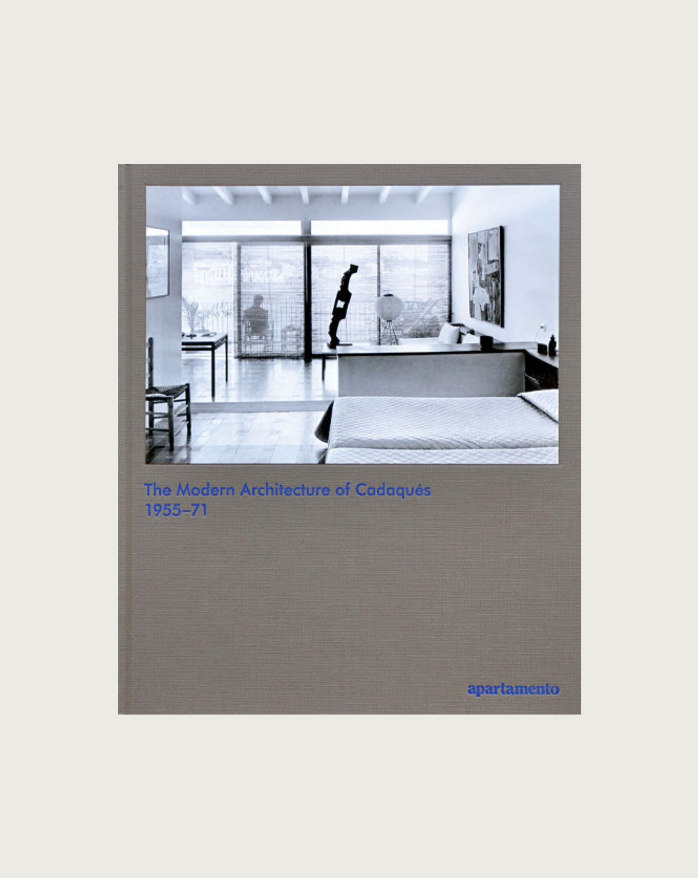 The book cover showcases a black and white photo of a modern interior with large windows and minimalist design, reflecting the creative relationships that shaped Cadaqués. The title reads "The Modern Architecture of Cadaqués: 1955-71" in blue text, set against a light grey background with "Maison Plage" at the bottom right.