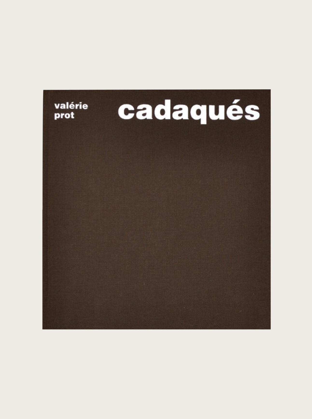 A book cover featuring a minimalist design with a brown background. The title "Valérie Prot: Cadaqués" is written in large white lowercase letters at the top right. The author's name, "Valérie Prot," appears in smaller white lowercase letters at the top left, hinting at its photography book essence with subtle nods to polaroids. This sophisticated piece by Maison Plage exudes an elegant simplicity.