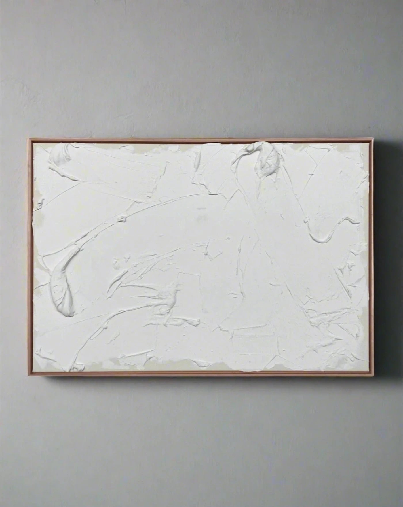 A minimalist white textured mixed media on canvas, framed in a light brown wooden frame displayed on a white wall, by Fulya Celik Art's "Eternal Energy II.