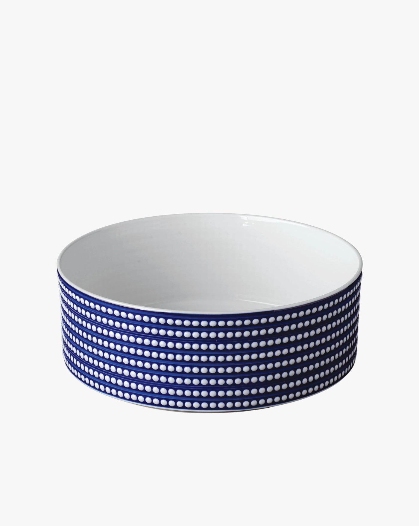 The Perlée Deep Bowl by LOBJET is a handcrafted white ceramic piece with an exquisite blue and white dotted exterior, ideal for enhancing any minimalist aesthetic.