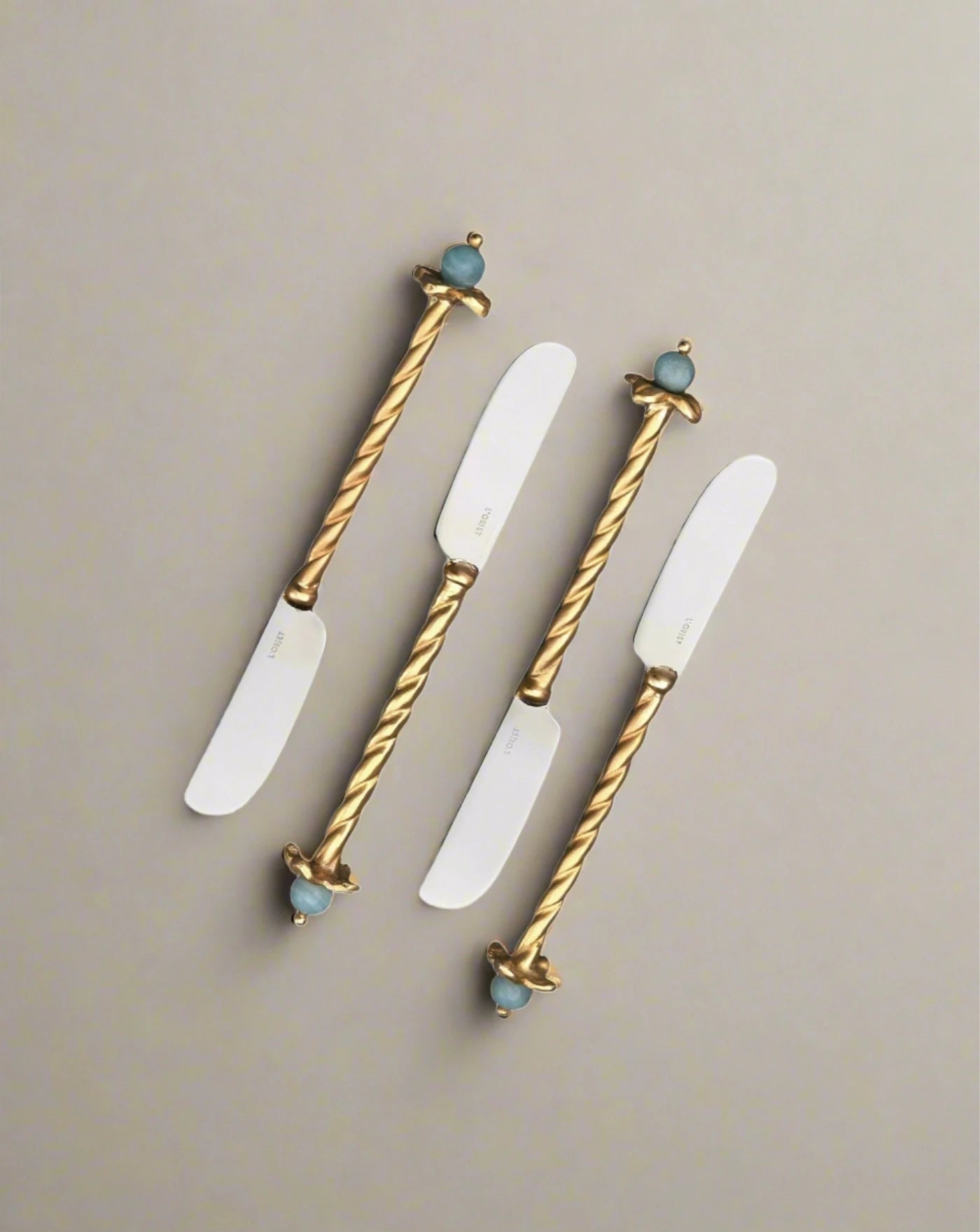 Four Venise Spreaders (Set of 4) with twisted golden handles and bird figurines on the ends, displayed against a white background, expertly crafted by artisans of Venice.
