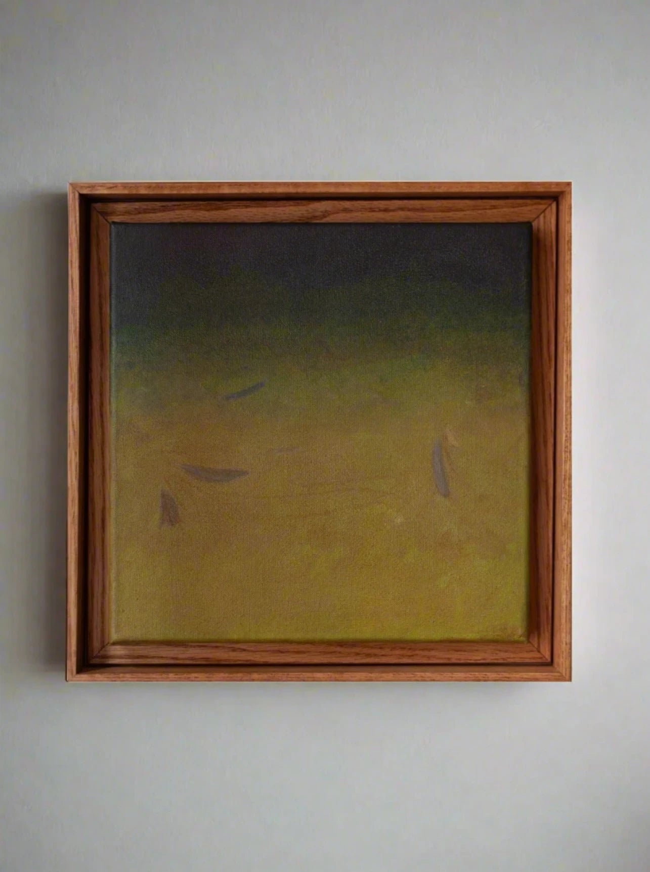 An abstract acrylic on canvas displayed in an oak frame, featuring Ponds and Breezes #7, 2023 by Rebecca von Matérn with a subtle gradient from dark to light green with faint, shadowy shapes resembling fish swimming.