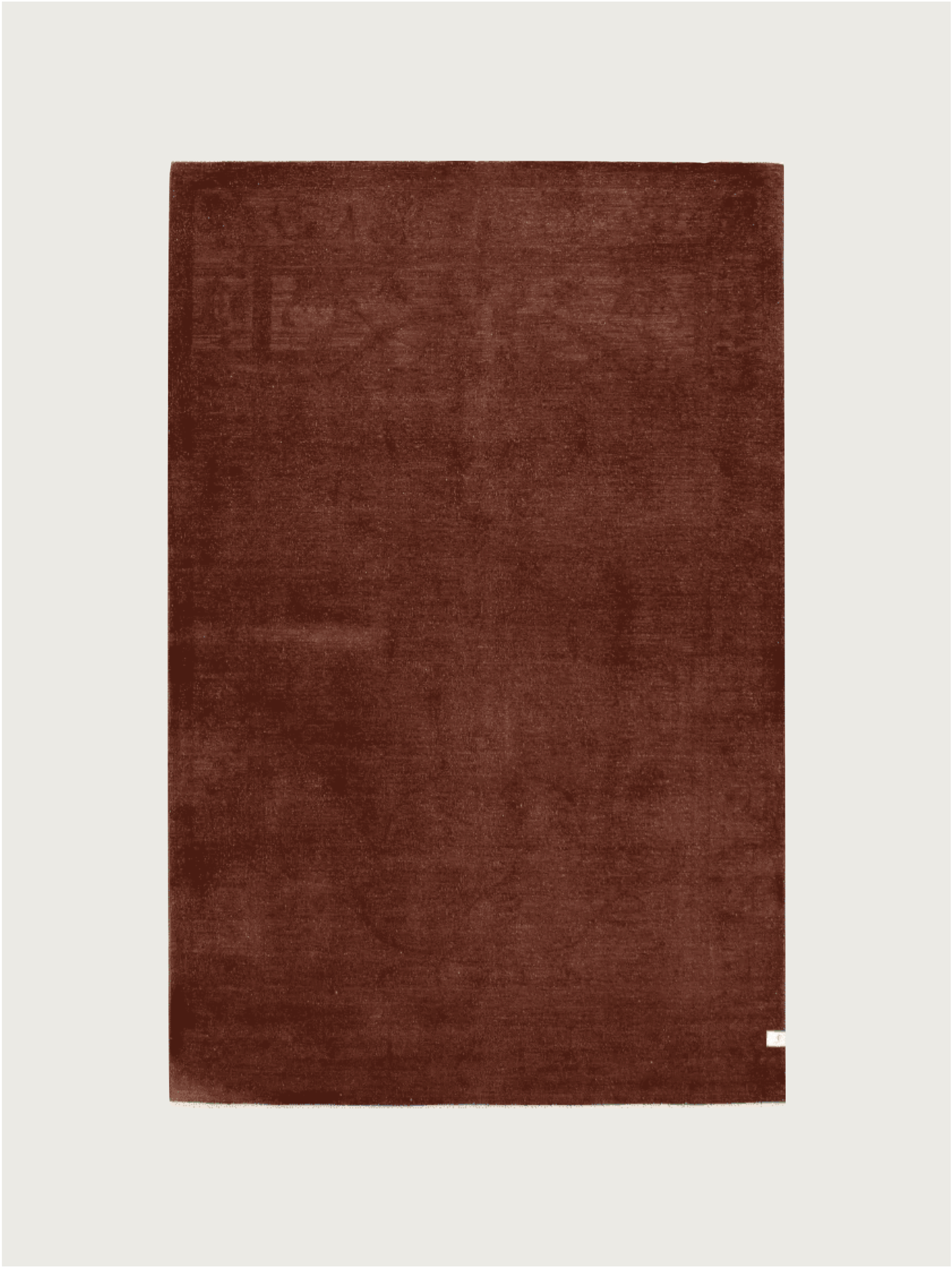 The Overdyed Rug in Russet (#305), by catalog:three, measures 178 x 277 cm and displays a large, solid brown wool piece on a plain white background. An elegant hand-knotted design, it features a small white tag in the bottom right corner for added classic charm.
