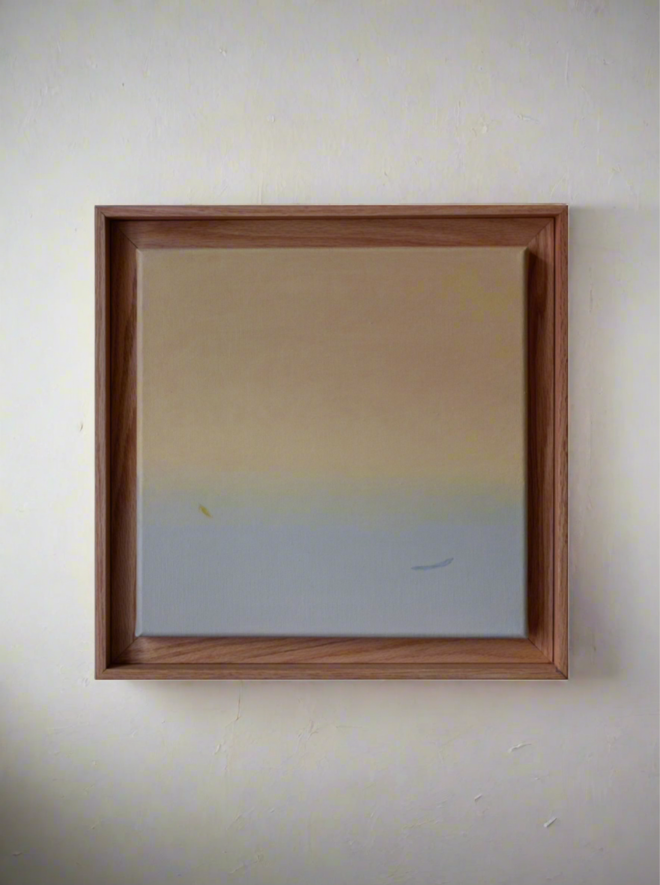 A minimalist painting featuring a soft gradient from beige to light blue, housed in an oak frame. Two subtle, small white brush strokes suggest birds in the skies.
Product Name: Untitled, 2024 by Rebecca von Matérn