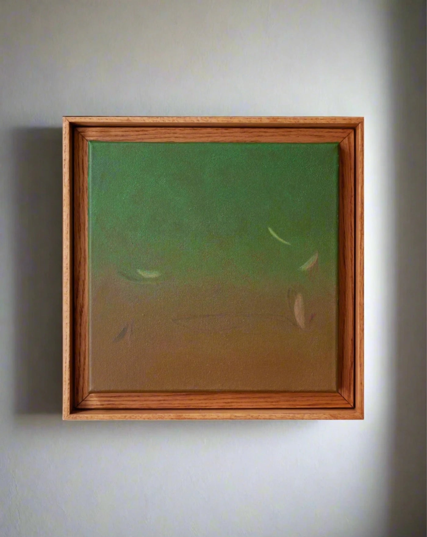 Rebecca von Matérn's "Ponds and Breezes #6, 2023," a framed abstract painting, graces the wall with minimalist charm. The artwork transitions from green to brown with floating lighter shapes that evoke movement and enhance the luxury interior's allure.