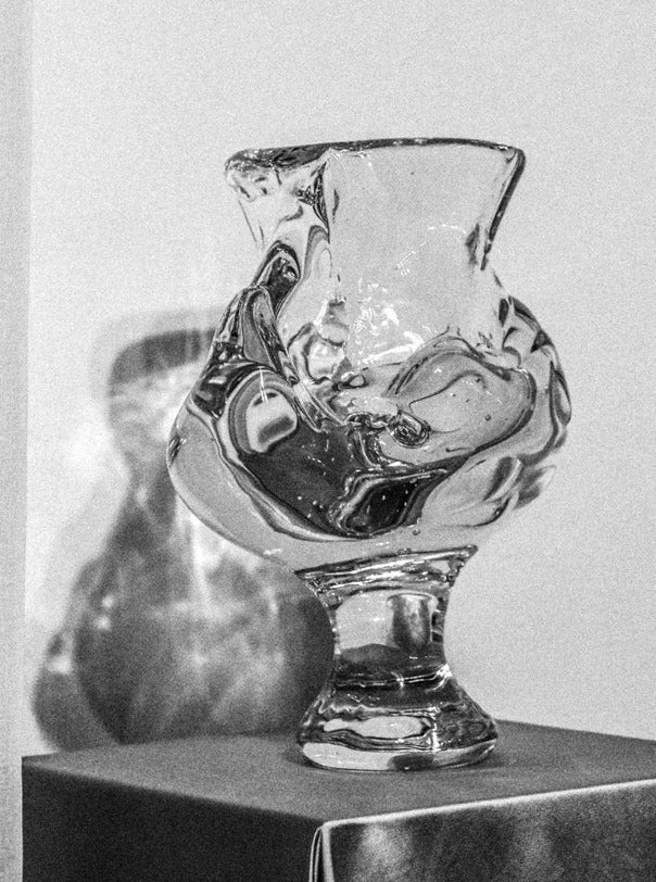 Handcrafted footed blown glass vase with elegant, curved silhouette and intricate detailing