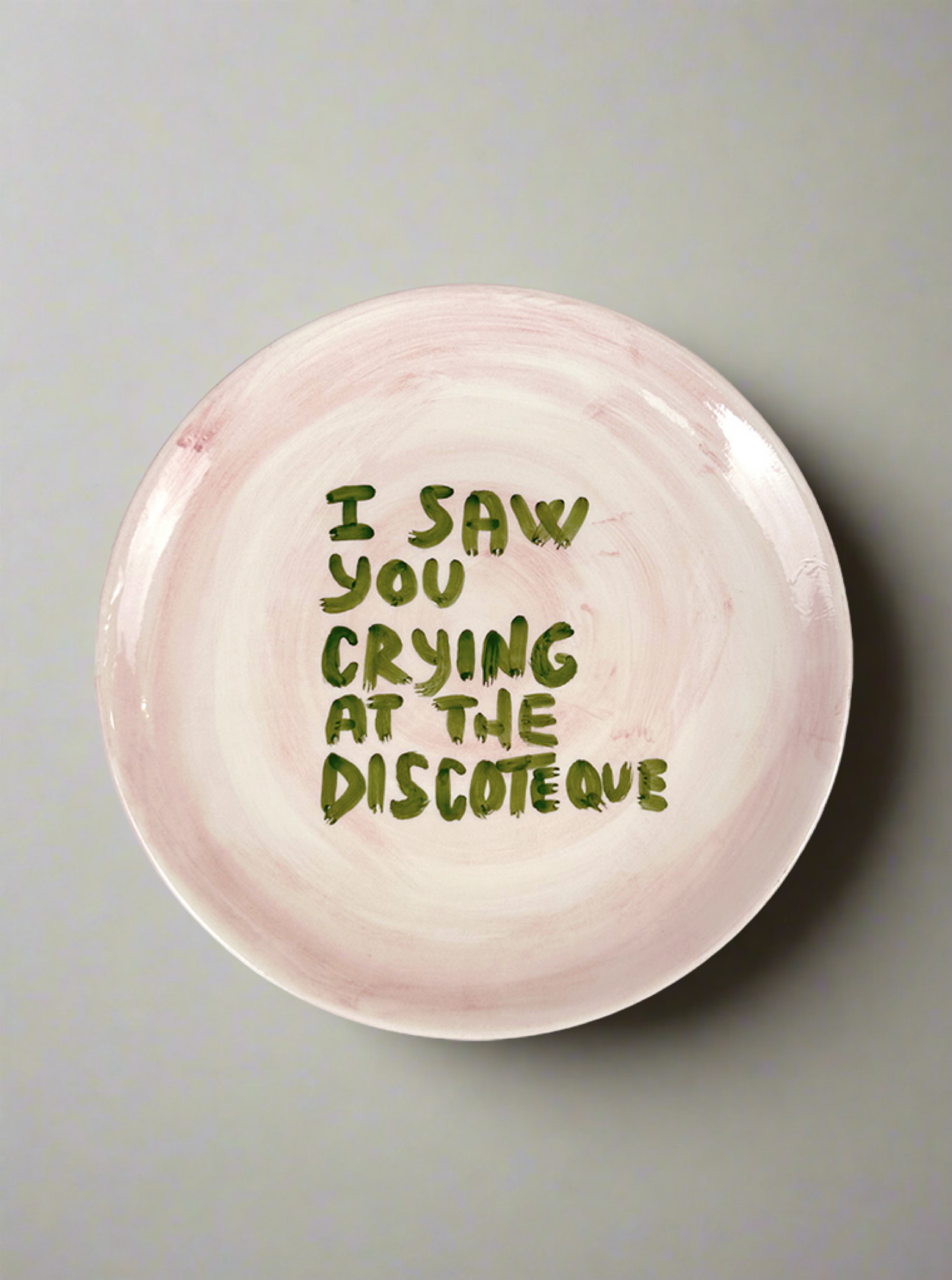The Musae Studio "I saw you crying at the discoteque" Plate features playful green lettering on a pink and white retro design—an eye-catching wall adornment ideal for lovers of 70s and 80s decor.
