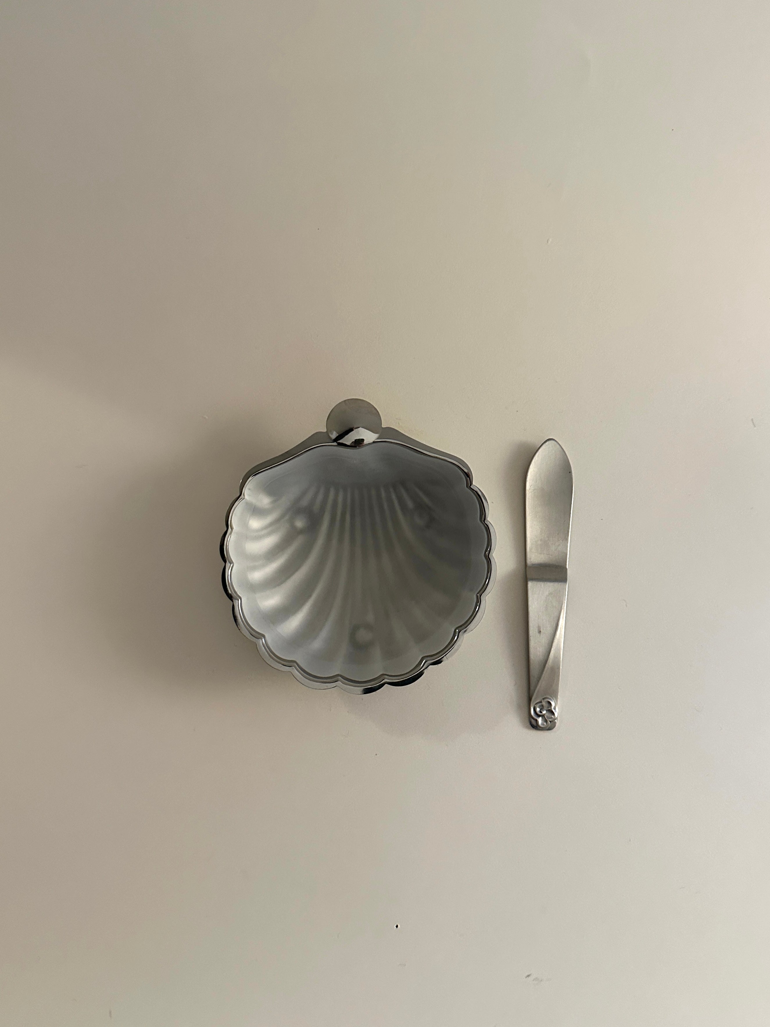 A white ceramic shell-shaped butter dish with a simple design