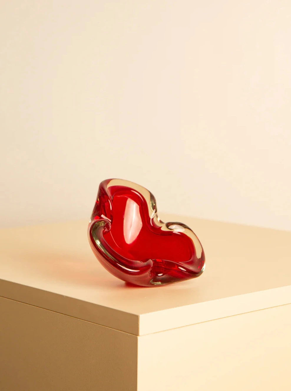 Close-up of a vibrant red Murano glass “Fleur” 60's vase with delicate floral patterns and intricate details, reflecting the elegance and craftsmanship of the 1960s era