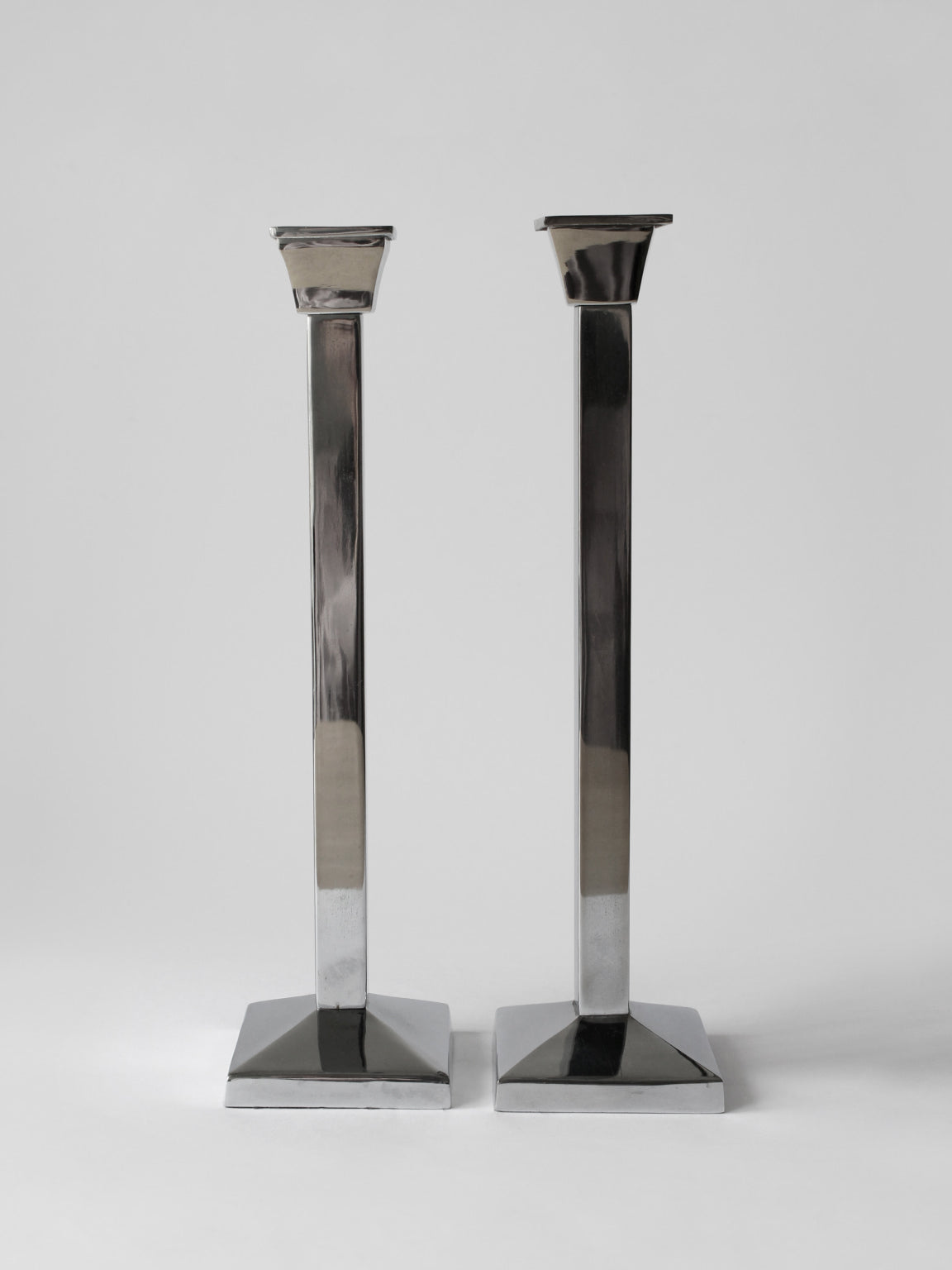 Paire de grands porte-bougies en métal poli avec effet miroir