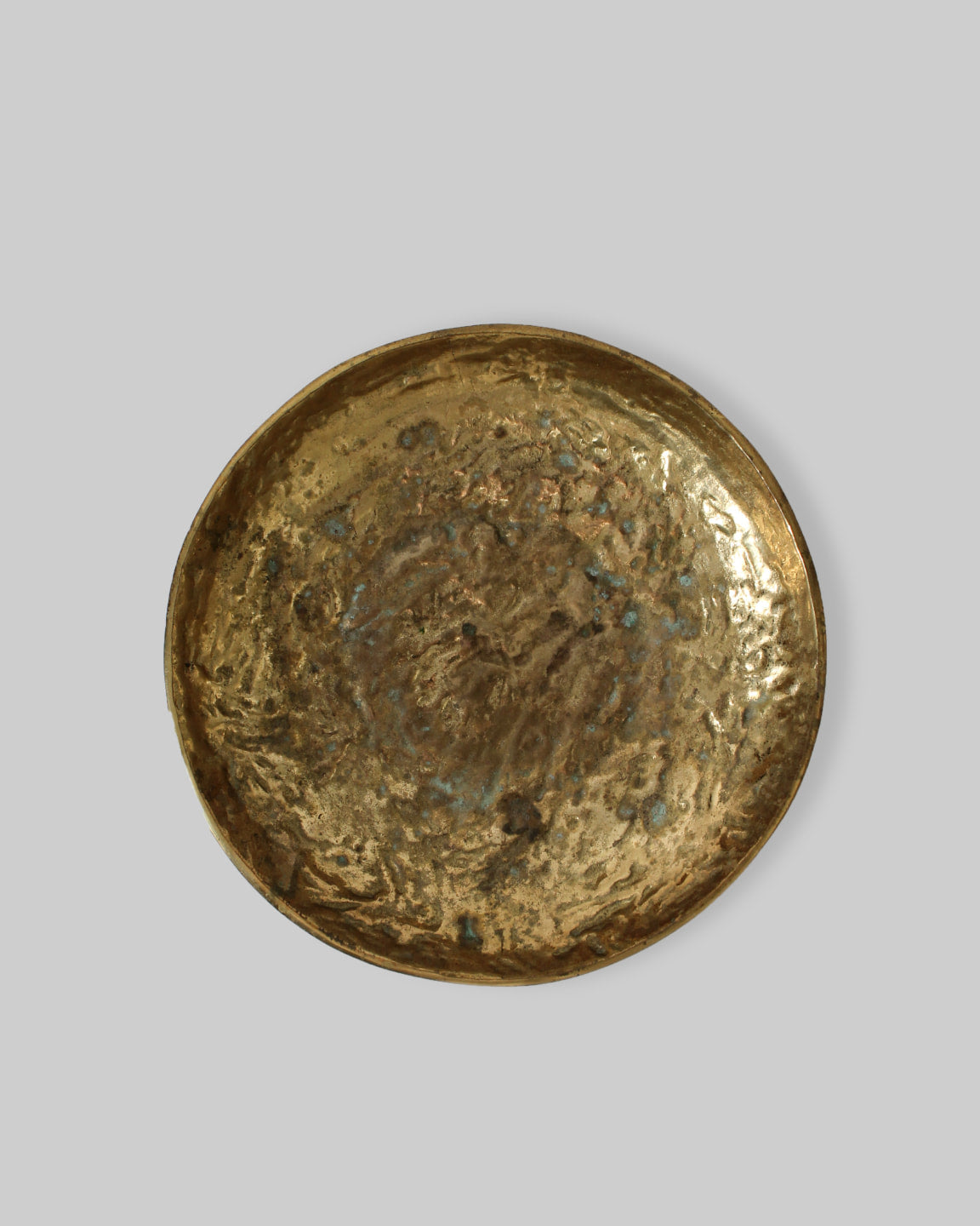 The Massive Organic Textured Brass Bowl by Vintage Stories features a round, hammered surface with uneven edges and natural patina, evoking the character of a vintage 1950s Swedish bronze bowl against a plain gray background.