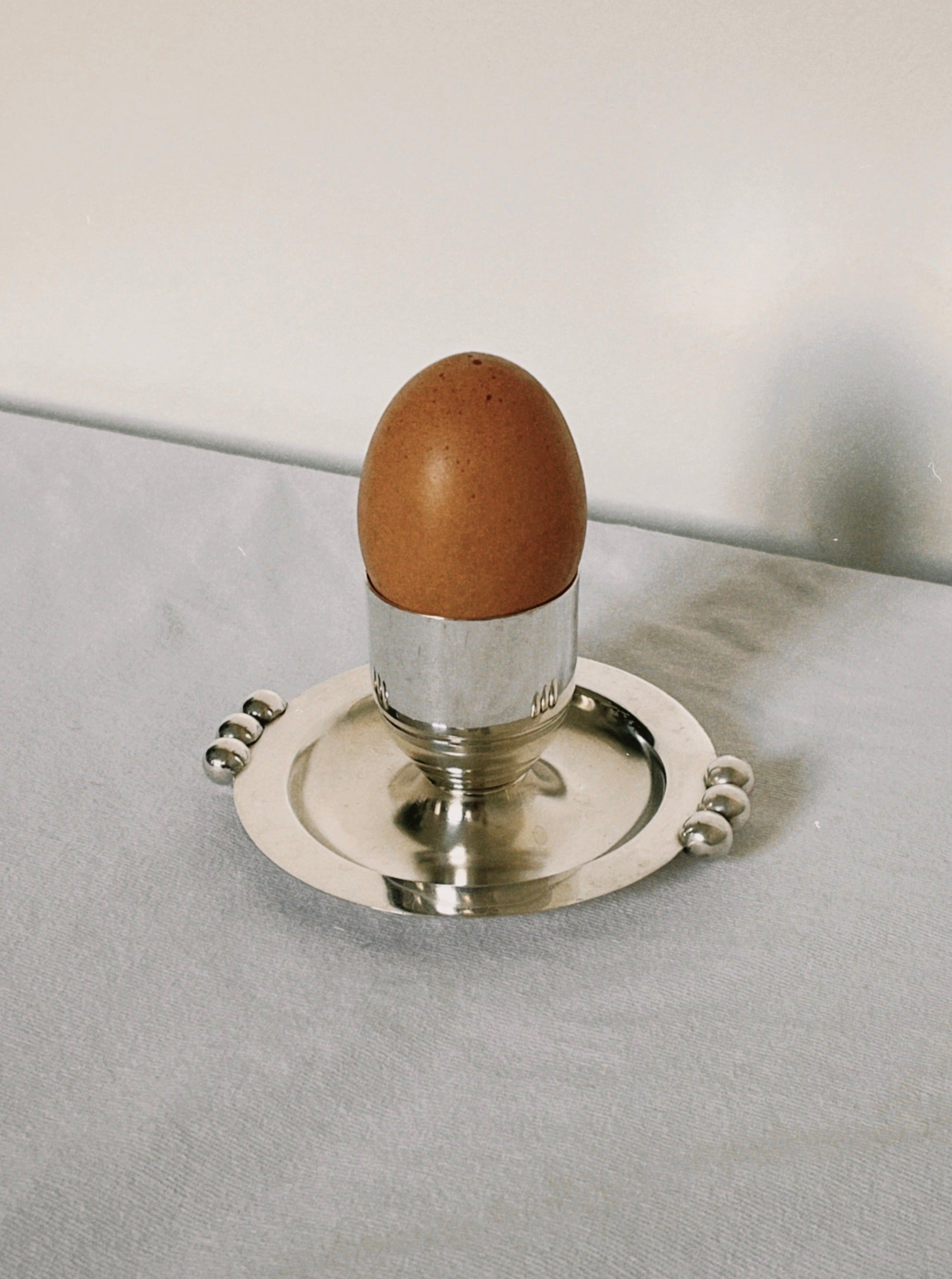 Shiny silver plated egg cup with intricate detailing and elegant design