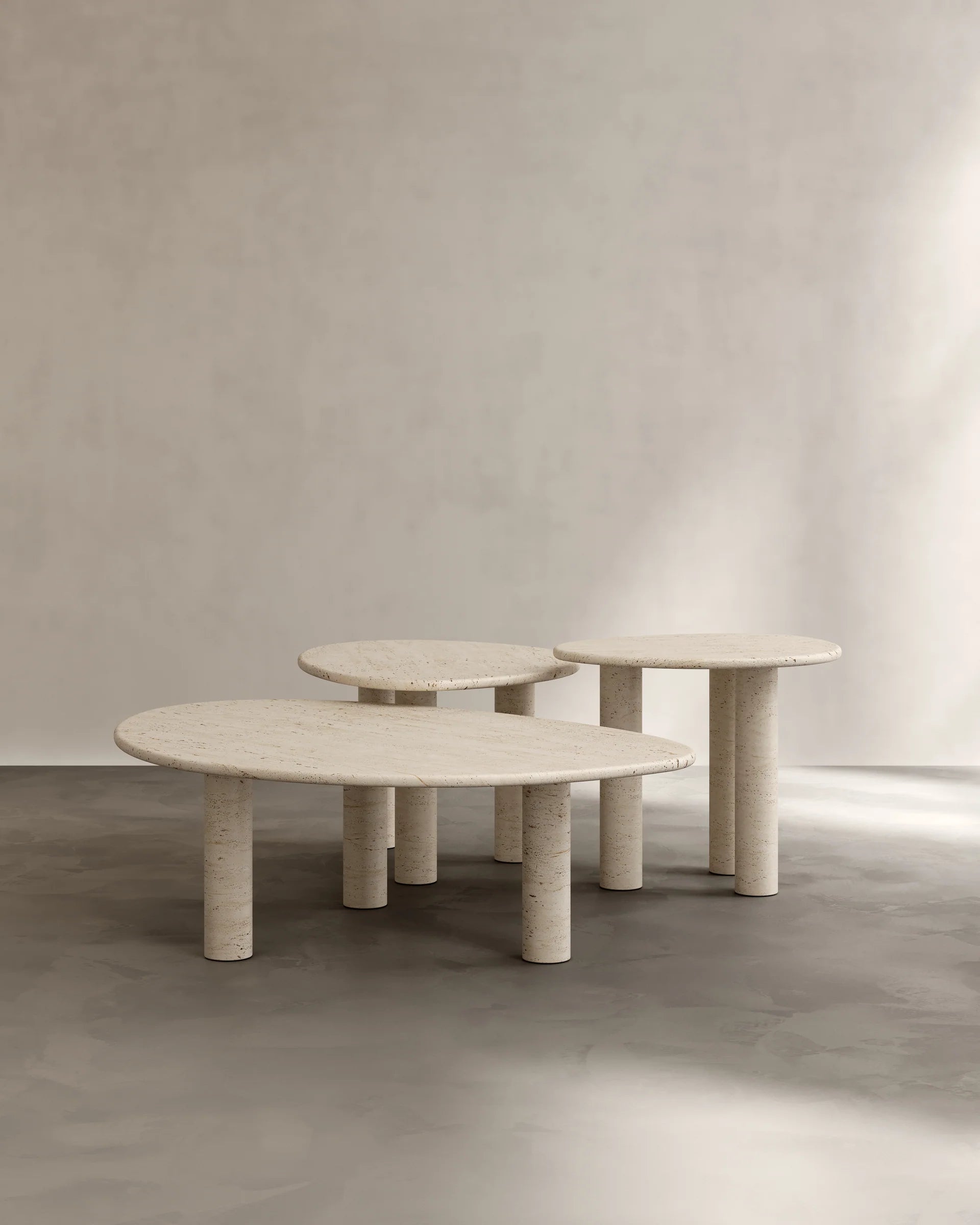 Sunpoet travertine coffee tables grouped arrangement showing sculptural cylindrical legs