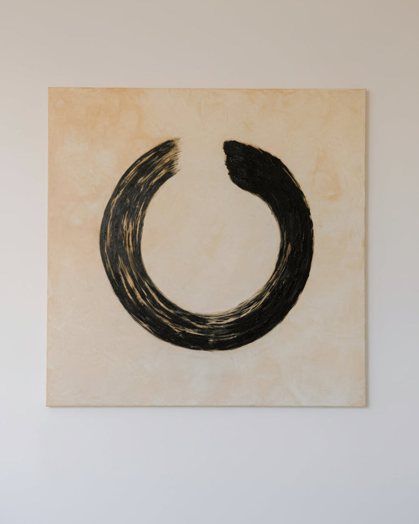 The Ensō Acrylic on Linen by Inga Dzintare features a minimalist black circular brushstroke, nearly forming a closed loop, on a beige linen canvas with a subtle texture, symbolizing enlightenment.