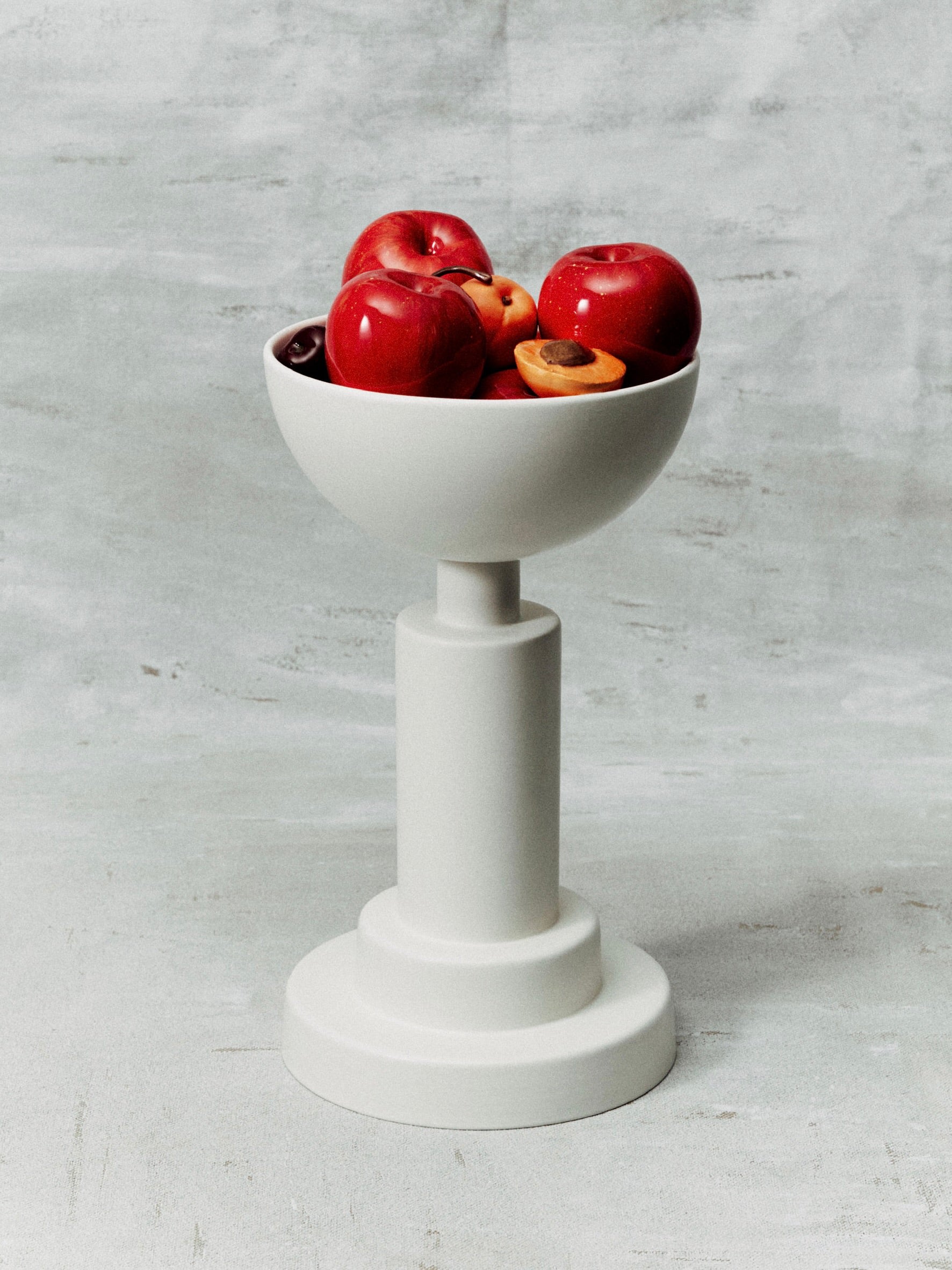 White glazed earthenware pedestal bowl filled with red stone fruits