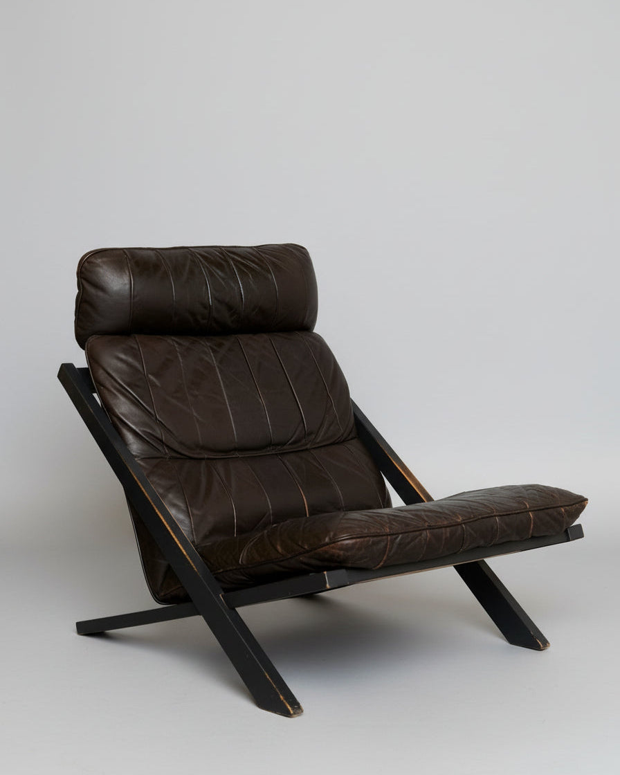 Brown leather DS80 lounge chair with black wooden frame by de Sede