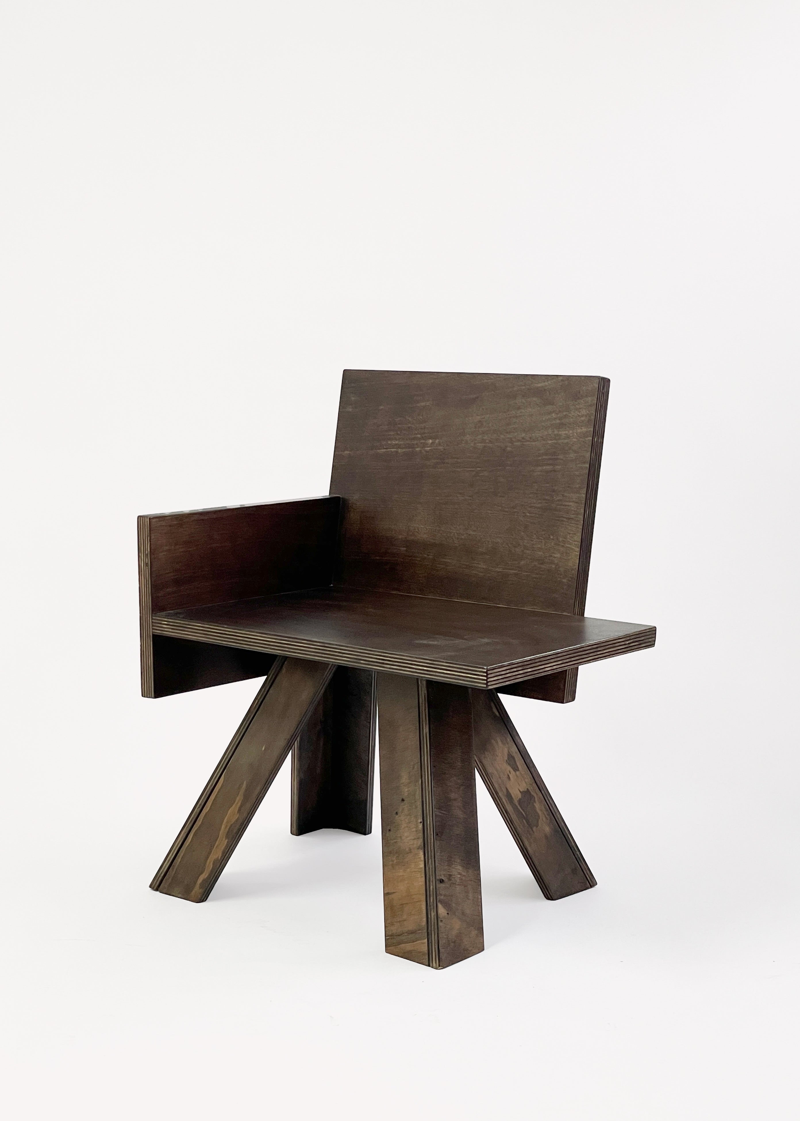 The End Table Chair by GOONS is a modern wooden chair with a dark finish, flat rectangular seat and backrest, single left armrest, and four wide angled legs—an artisanal piece from GOONS shown against a plain white background.