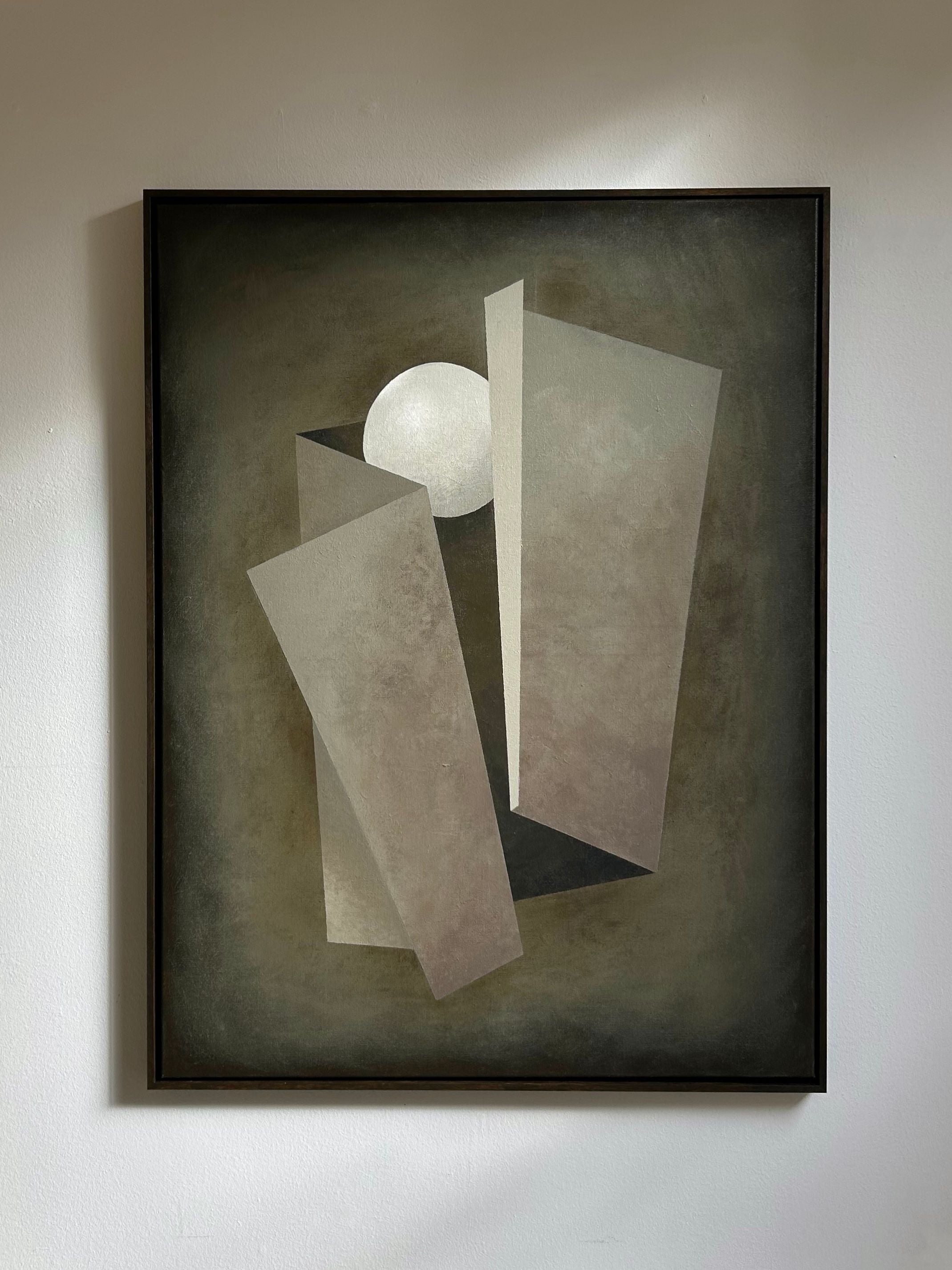 “Unfolding” by Iris Bavelaar is an abstract painting with geometric beige and gray shapes on linen canvas, a white circle near the top, and a dark textured background. Finished with a sleek wooden frame.
