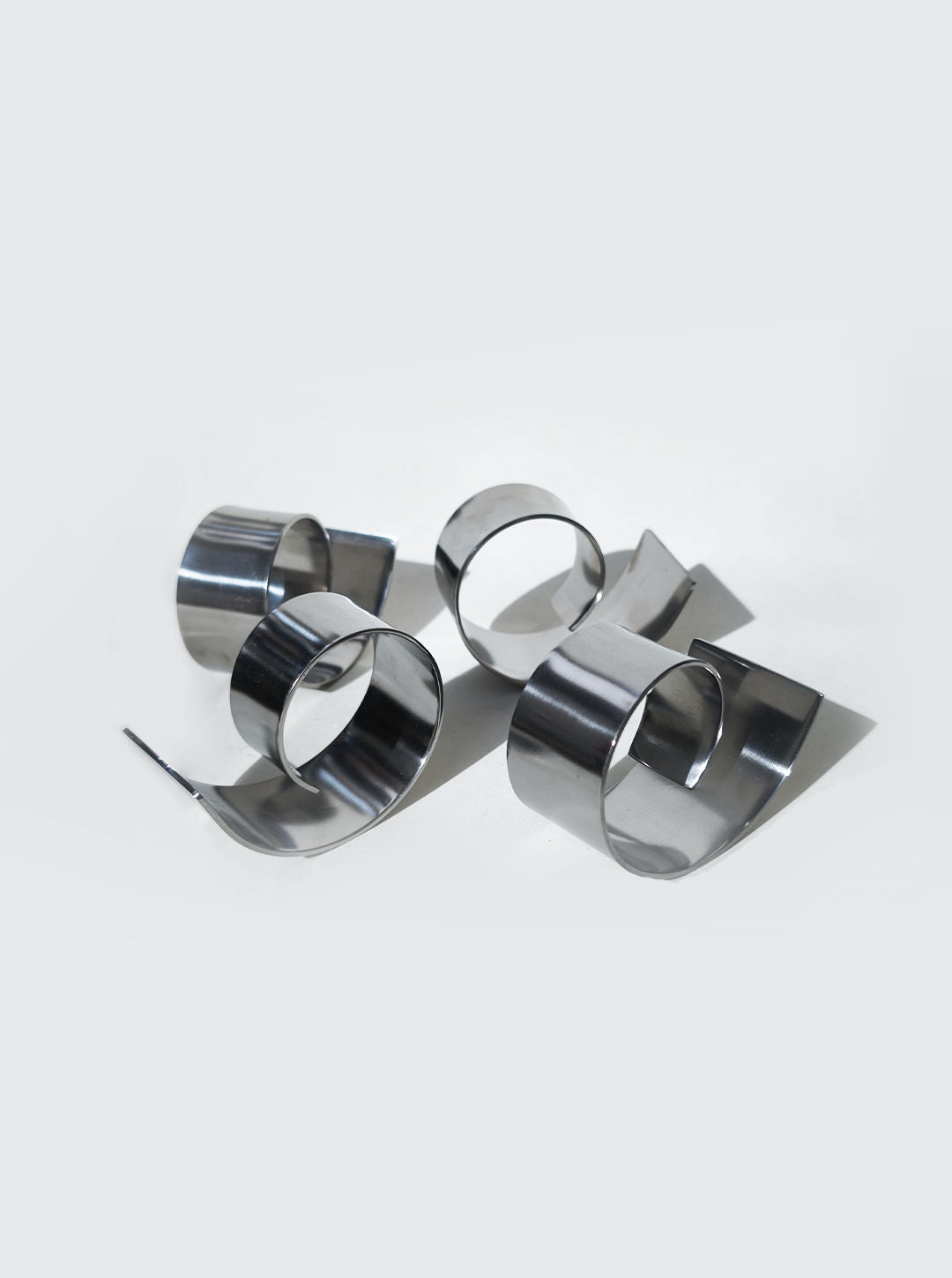 Set of polished stainless steel spiral napkin rings for elegant table setting