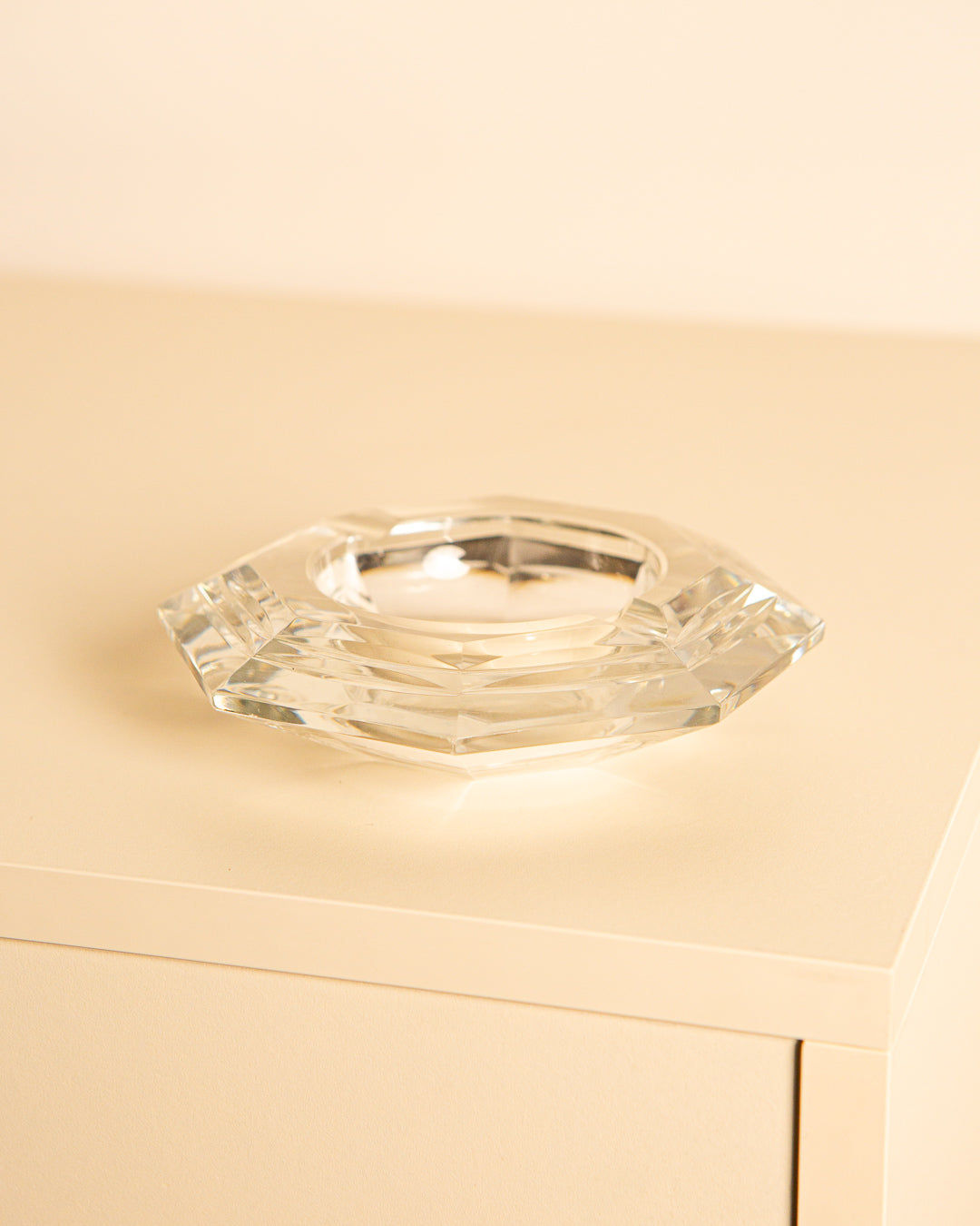 Clear crystal octagonal ashtray from 1960s Italy on beige surface