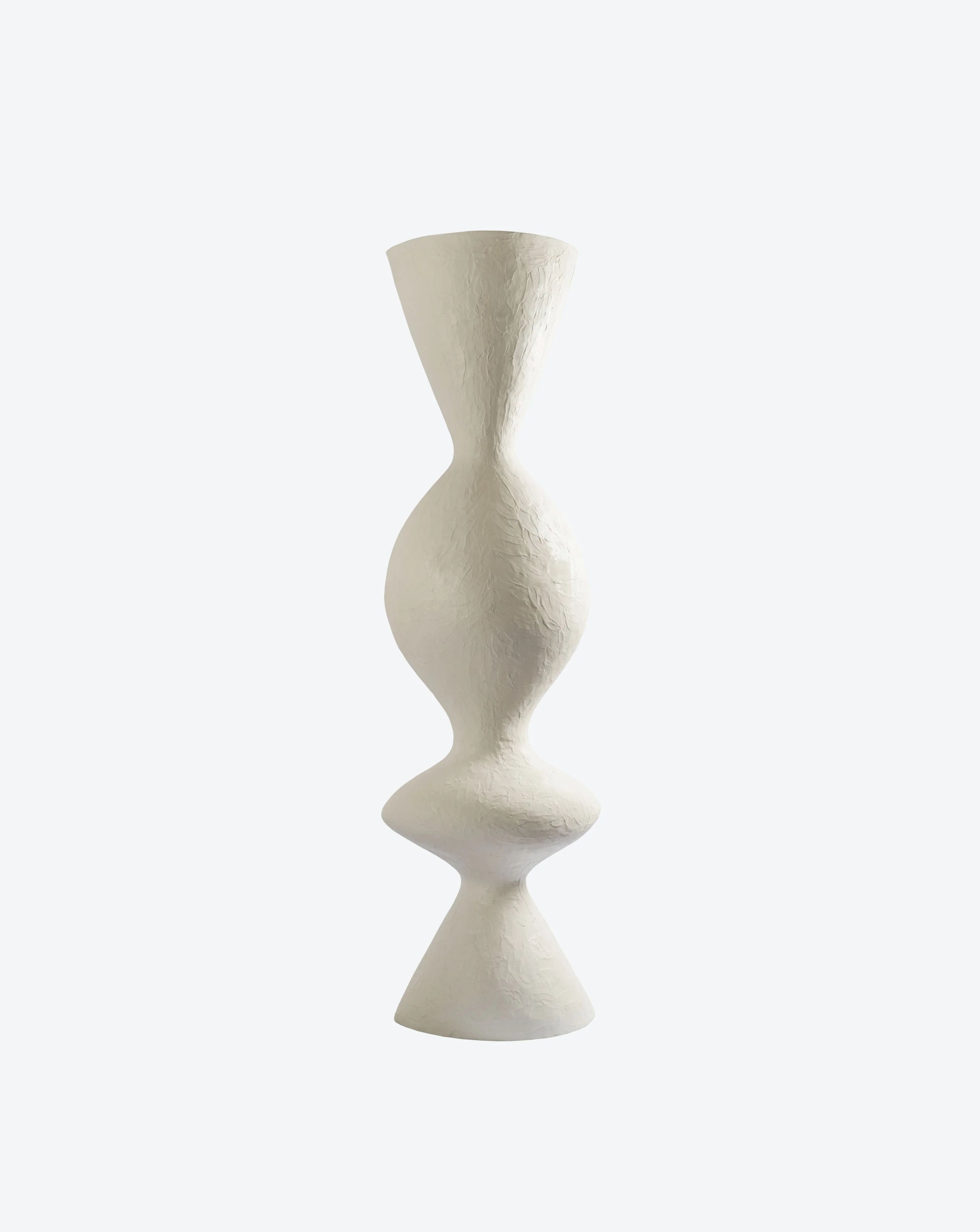 The "Venus II" Floor Lamp by Ransom & Dunn, with its tall and textured design, handcrafted in Portugal, features a distinctive sculptural shape highlighted by a wide center and narrow top and base. Crafted from eco-resin, its elegant form stands out beautifully against a plain background.