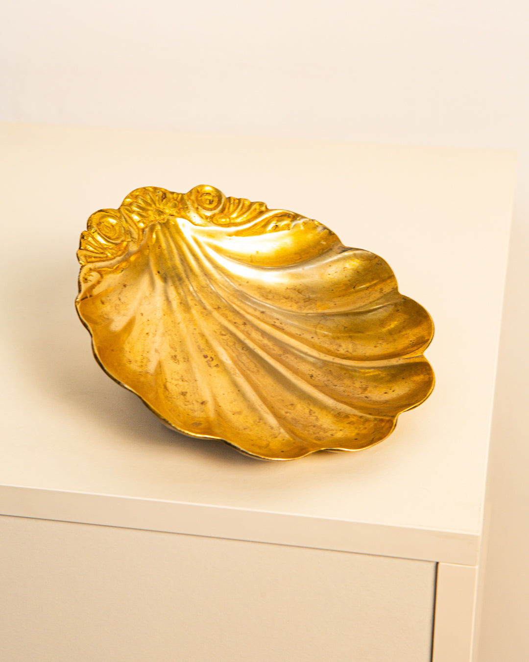 The Large Vide-poches Saint Jacques in Brass 60's by Treaptyque, featuring ornate scallop shell detailing, rests on a white surface against a plain light background.