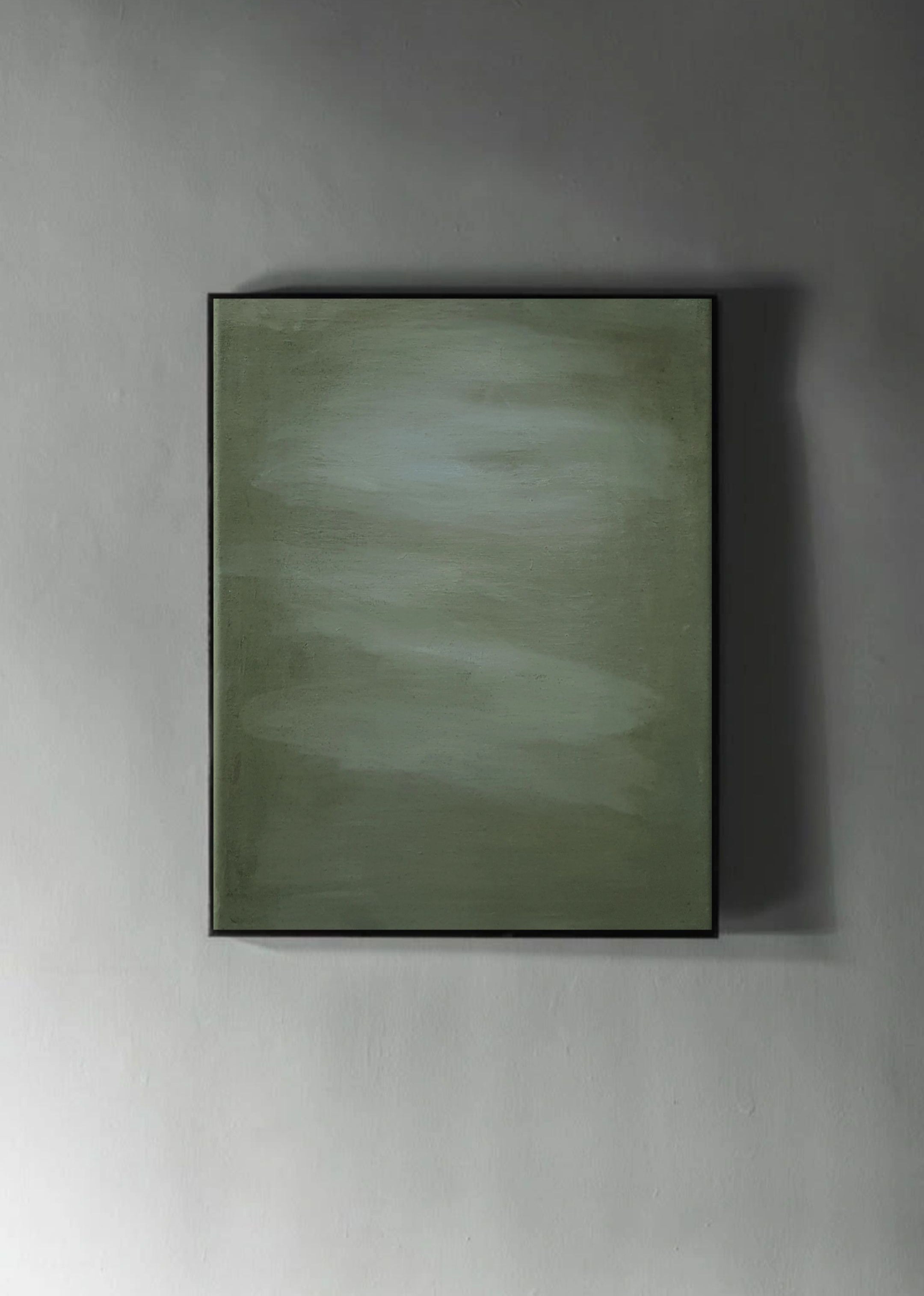 Let go of Gravity" by Yeliza Gevorgyan is a rectangular abstract painting in soft green and gray, featuring a subtle, smooth texture with no distinct shapes. It hangs on a gray wall, casting a slight shadow to the right.