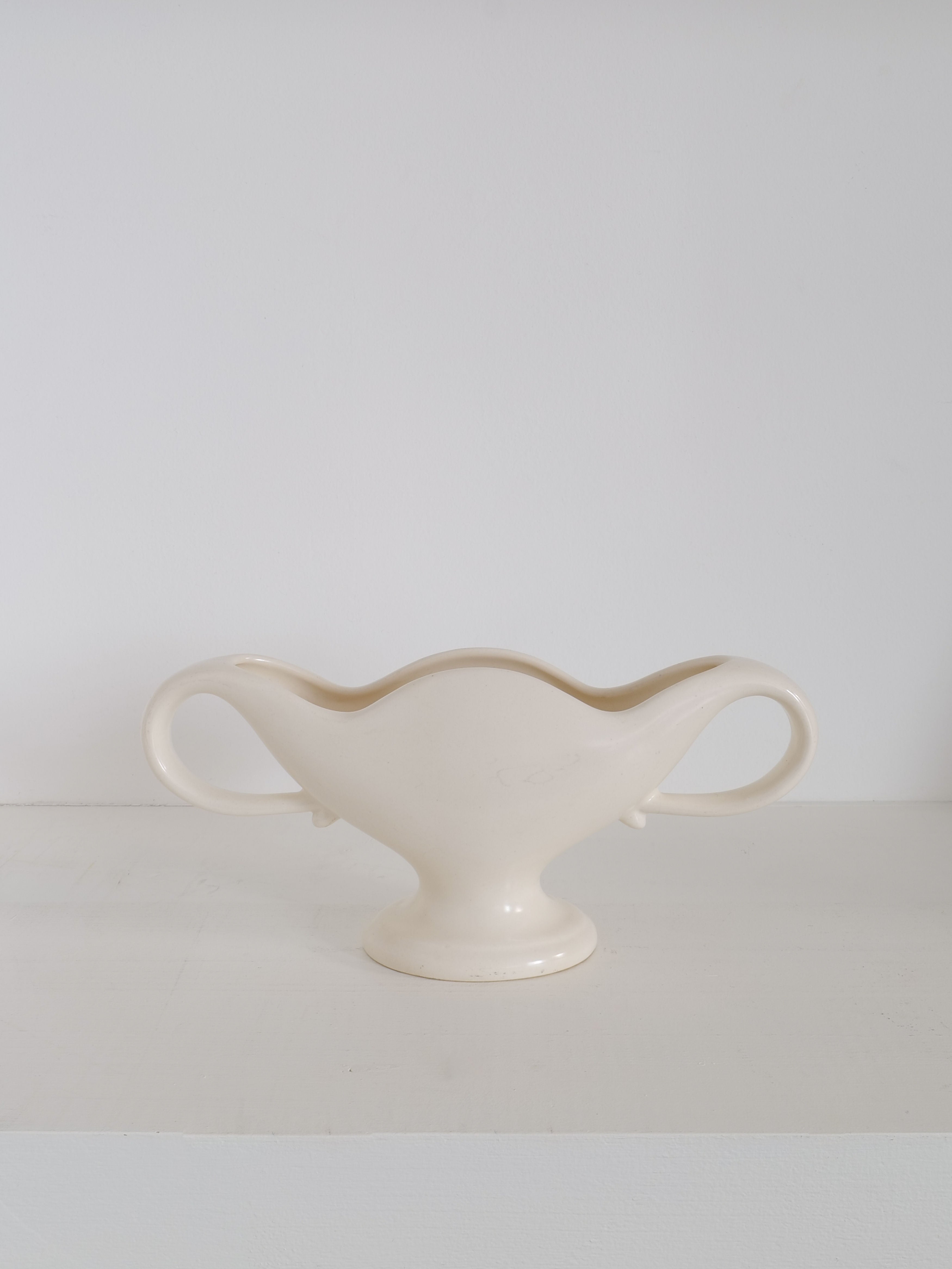 The Mini Mantle Vase 1930s by Collection apart, crafted from white ceramic with an elegant, elongated shape and two symmetrical handles on either side, sits on a white surface against a plain white background. The piece features smooth curves and a glossy finish reminiscent of Fulham Pottery.