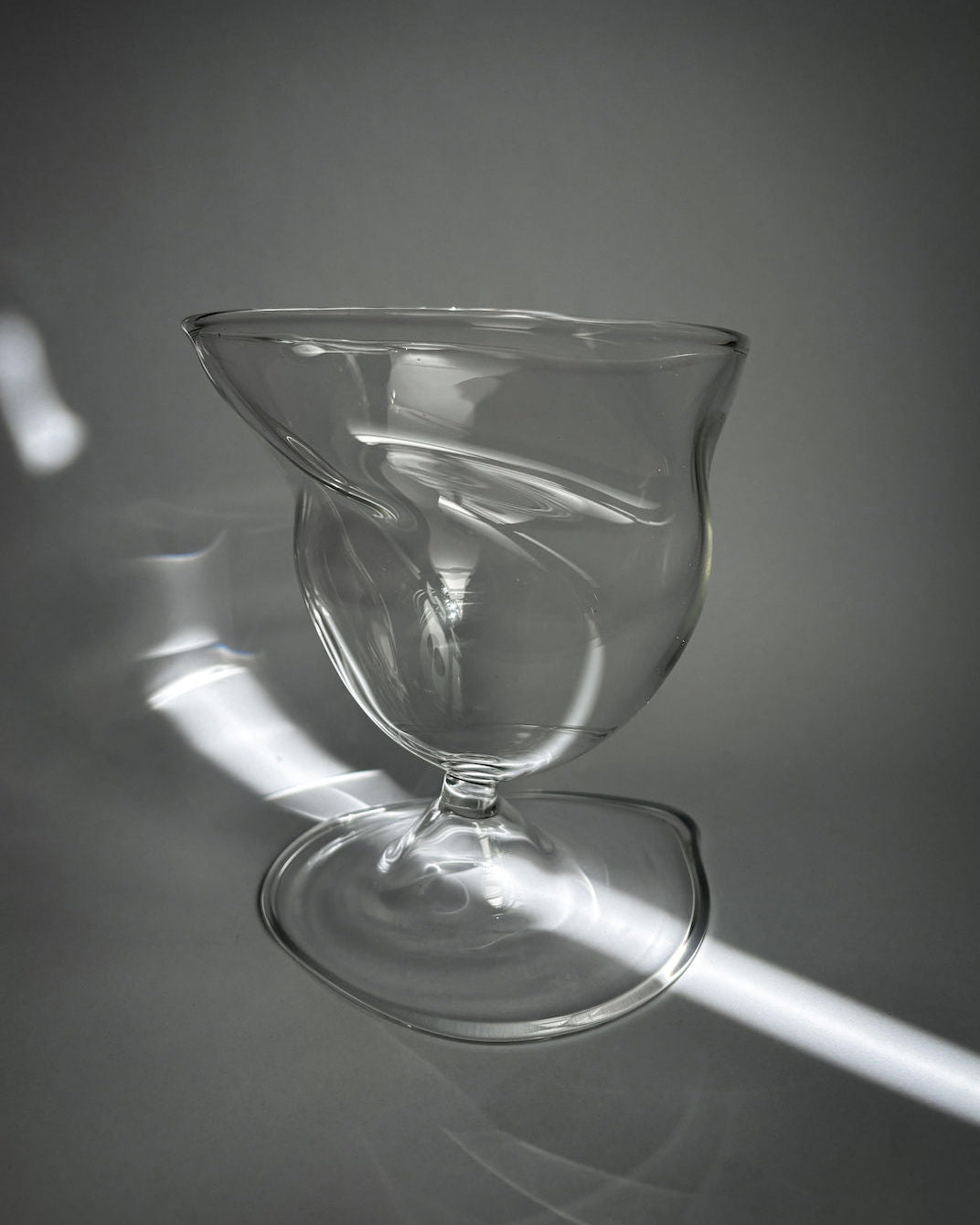 Clear twisted glass brandy snifter with sculptural swirled bowl design