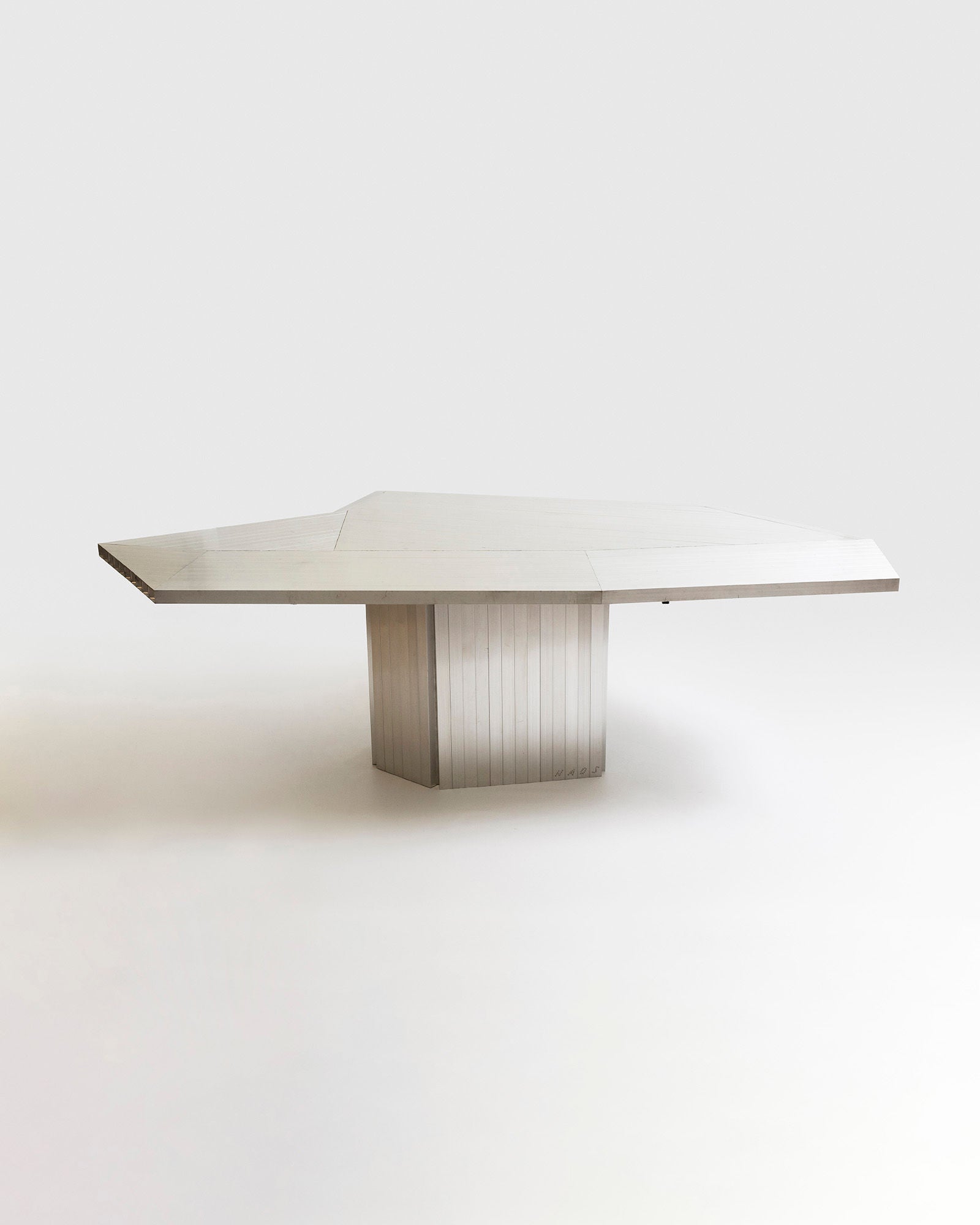 Modern aluminum dining table with fluted pedestal base by Studio HAOS