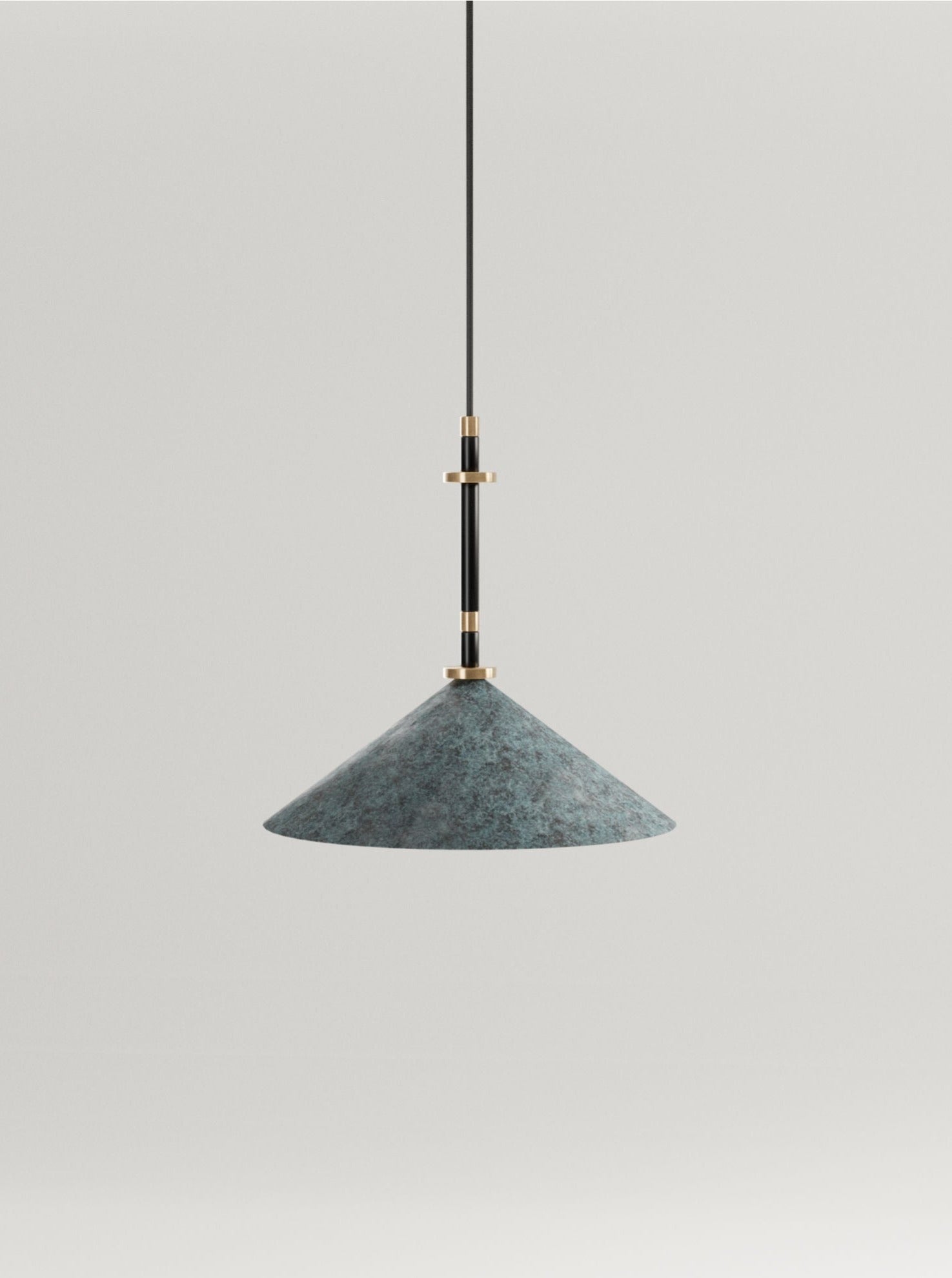 A minimalist ceiling light with a broad, textured grey lampshade and sleek solid brass fittings, hanging against a clean, white background from the Marine Breynaert Louisa I collection.