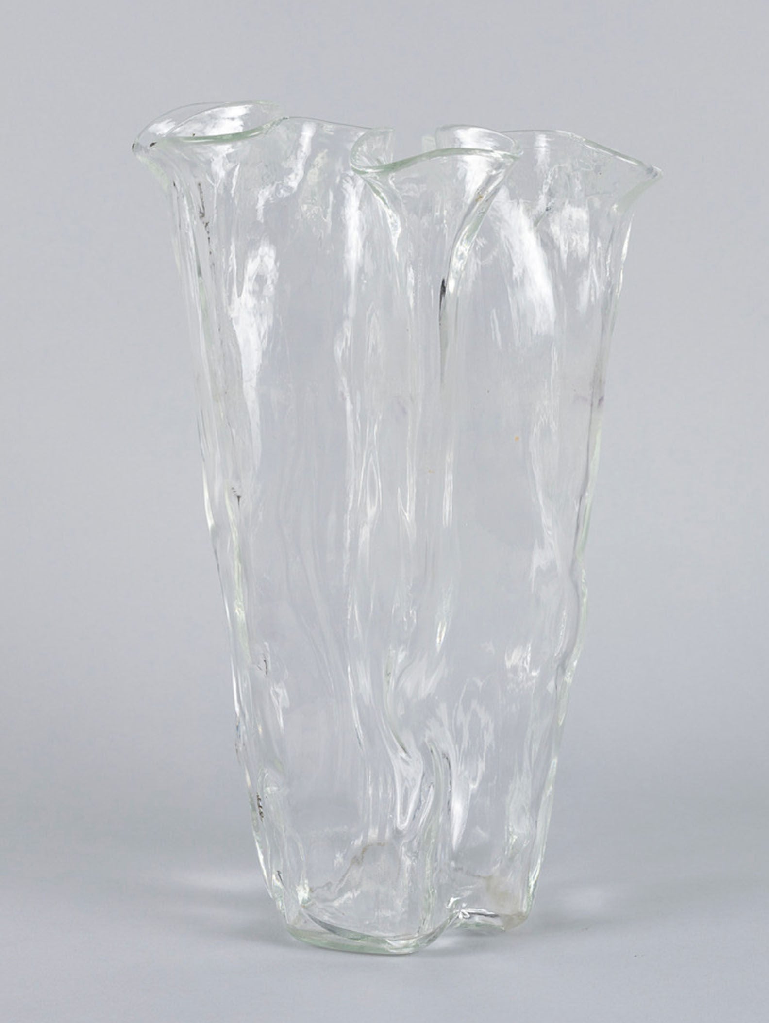 Part of the RELIC LONDON collection, the Organic Glass Vase by Pertti Kallioinen features a clear, abstract, wavy design with overlapping sections that create a fluid and organic shape.