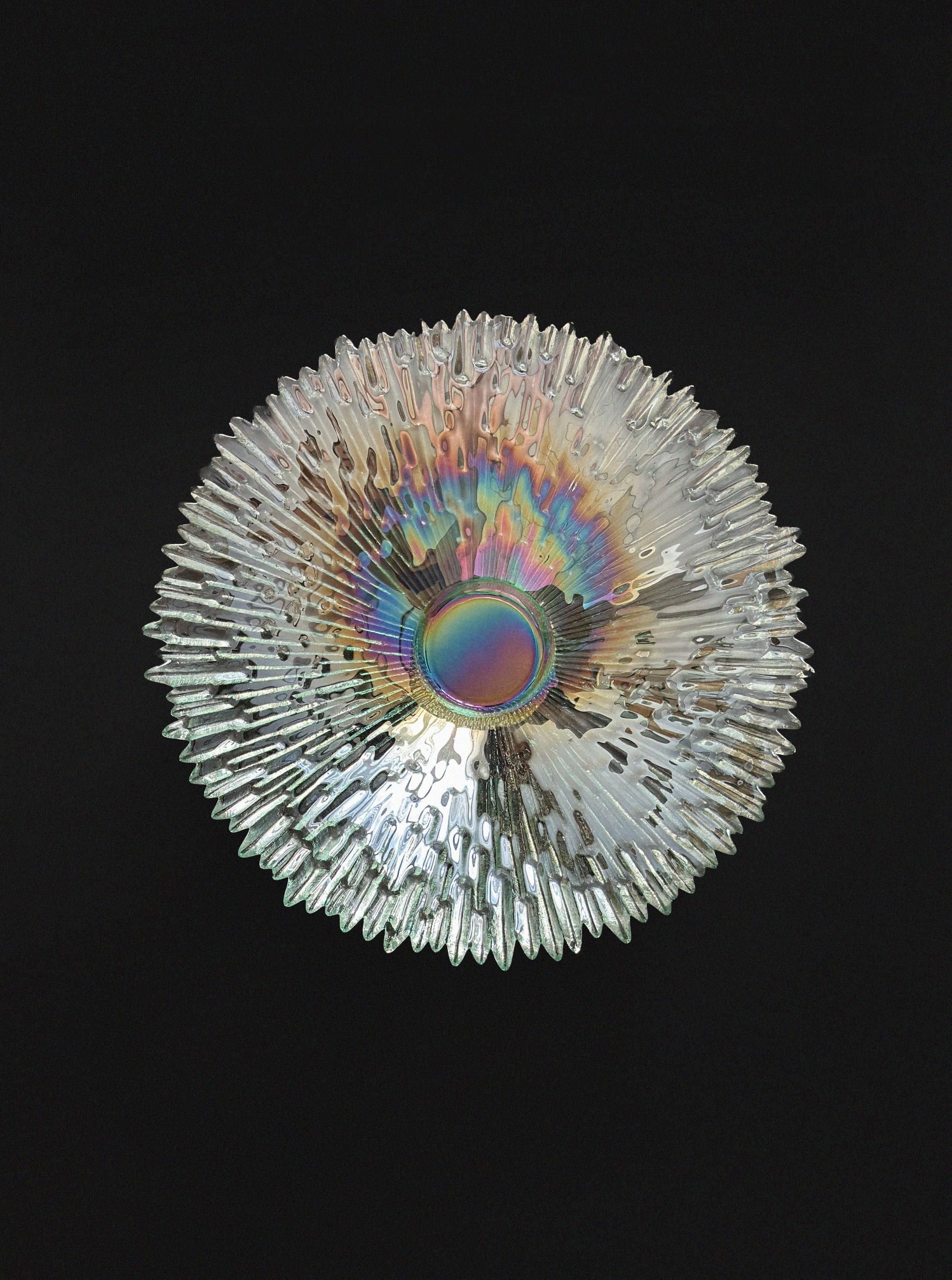The Tapio Wirkkala "Revoltunet" Art Glass Bowl by Vintage Stories, with textured iridescent glass and sunburst-like spikes, is showcased against a solid black background.