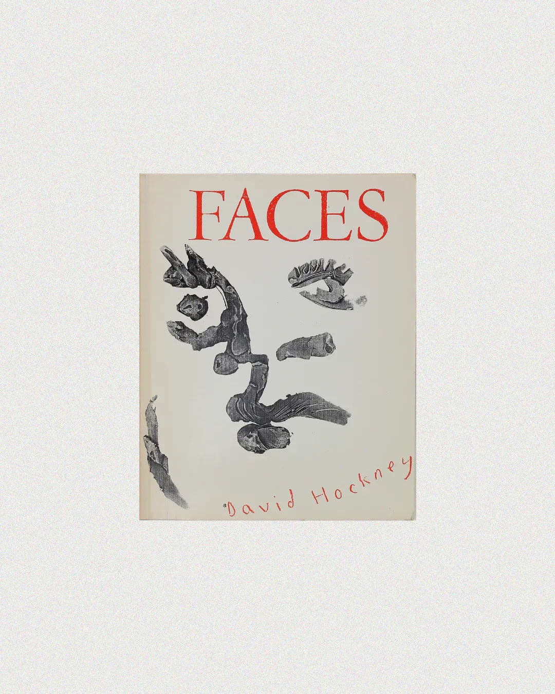 The cover of "Faces by David Hockney" from Boga Avante Shop features abstract black brushstrokes creating a face on a white background, with Hockney's handwritten name in red at the bottom, perfectly capturing his unique artistic style.