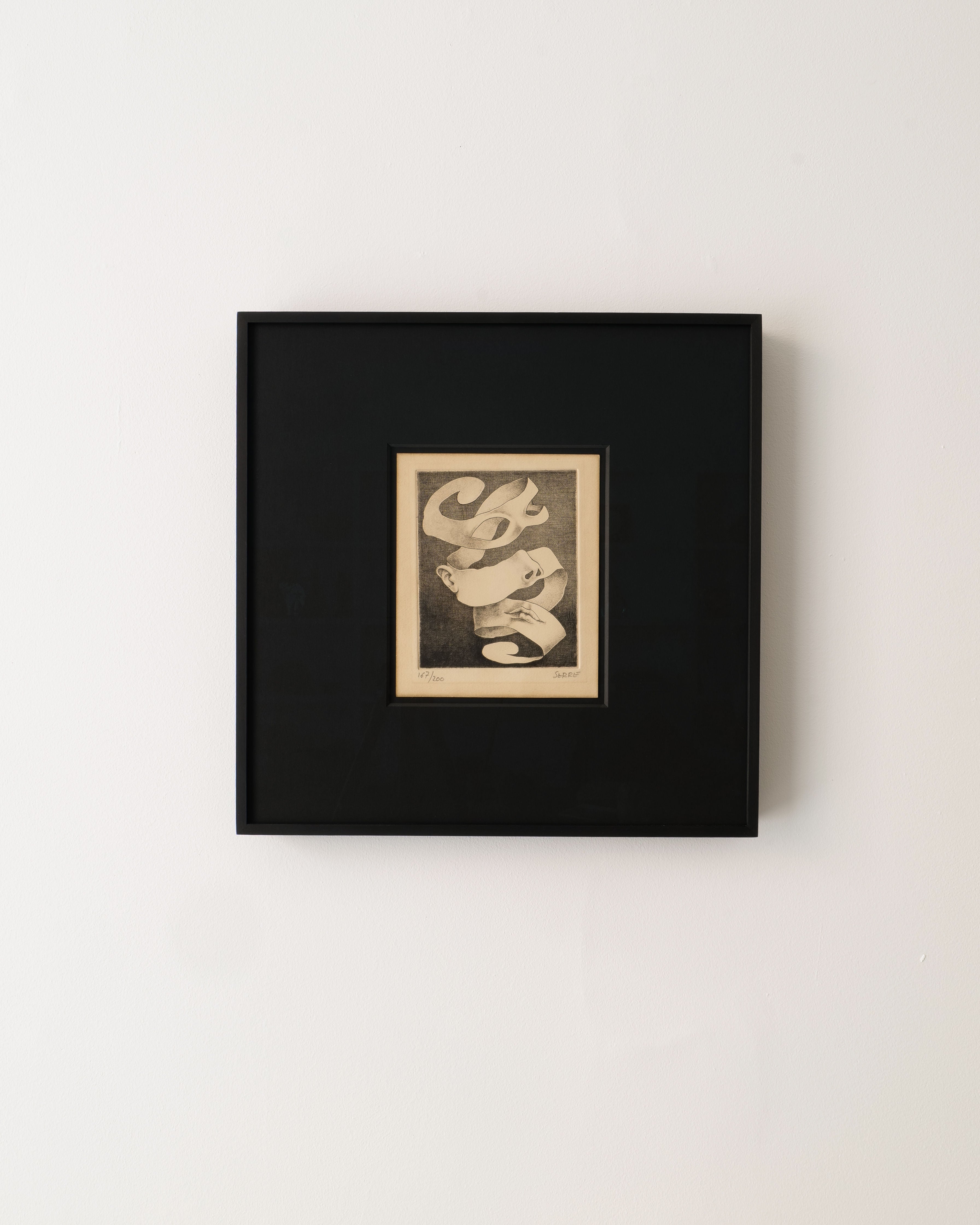 A Surrealist Engraving by Claude Serre (1938-1998) from Collection apart hangs on a white wall, showcasing abstract black-and-white swirling ribbons within a wide black mat and black frame.