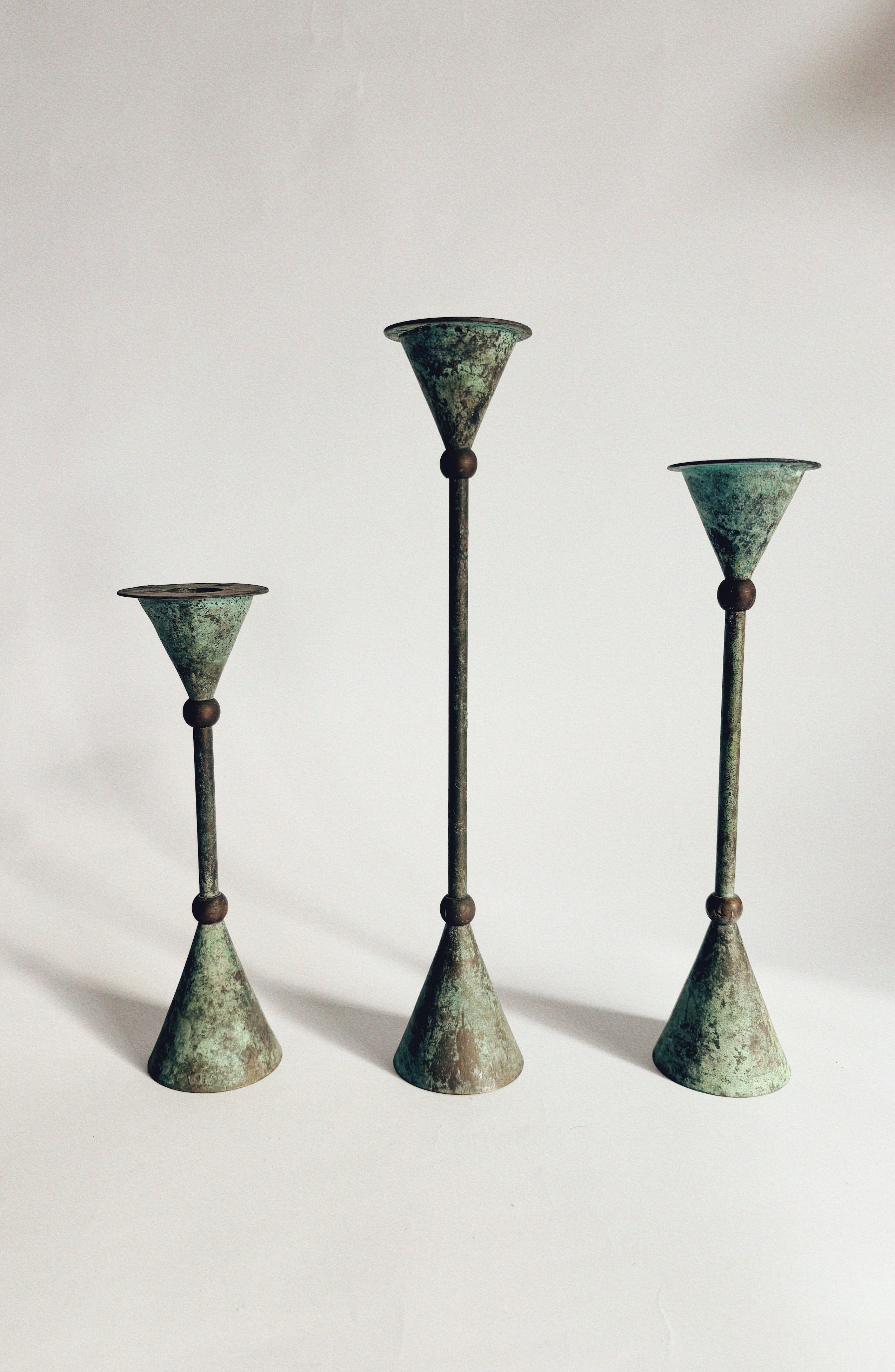 Set of 3 Postmodern 80's Candle Holders by Huerto shown in vintage condition against a white background, each featuring a flared top and base, slender stem with green patina, and spherical accent at the center.