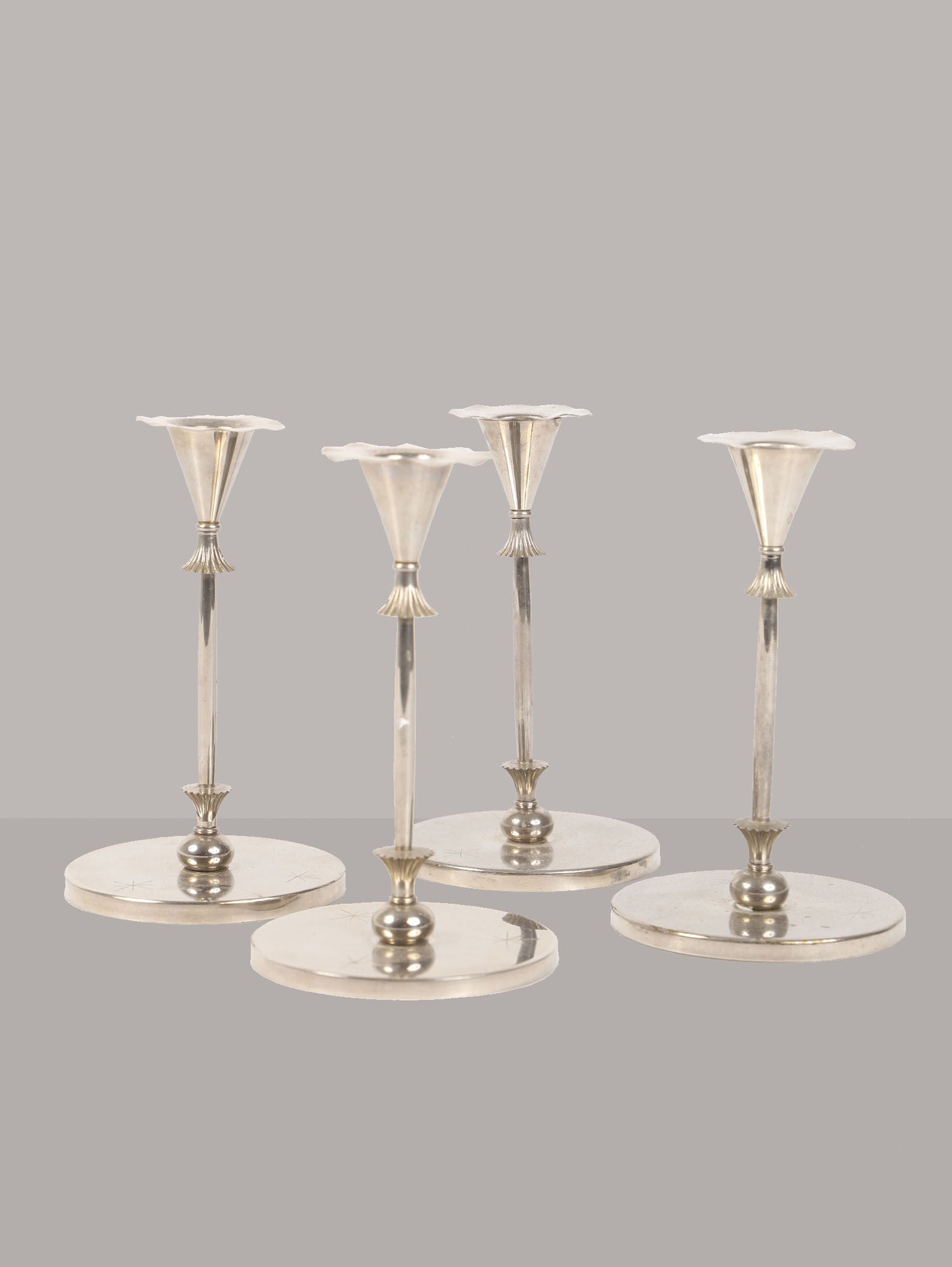 Four elegant O.H. Lagerstedt candlesticks by Skultuna, from the 20th century, stand on a neutral gray backdrop. Each piece showcases decorative detailing on its round base and tapered stem, offering a refined uniformity. Brand: RELIC LONDON.