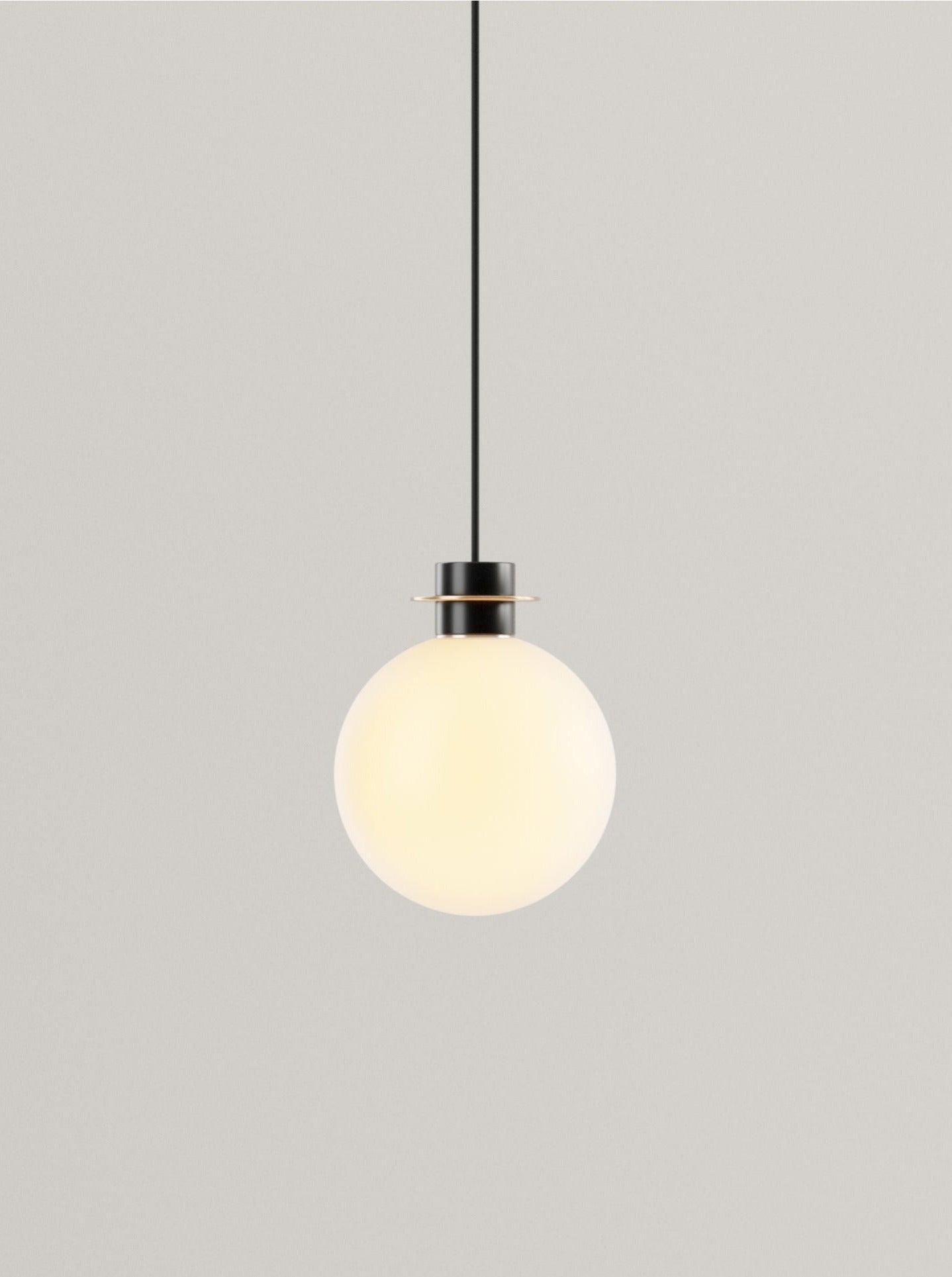 A Marine Breynaert Nova Ceiling Light featuring a single hand-blown glass globe hangs from a sleek black cable against a plain gray background.
