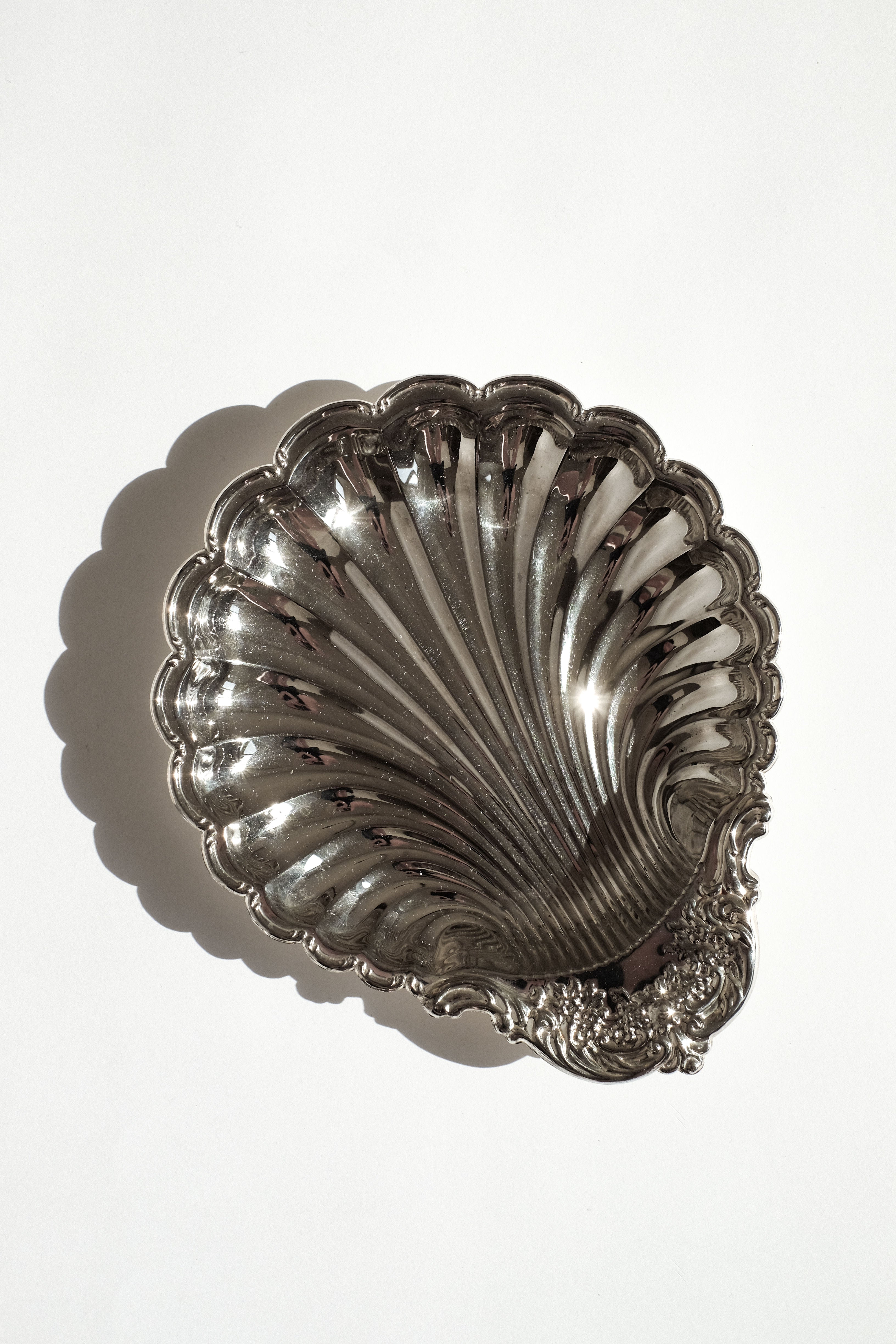 The Large Silverplated Shell Dish by septembre studios features ornate lower edge detailing and is photographed on a white background with a soft shadow to the left.