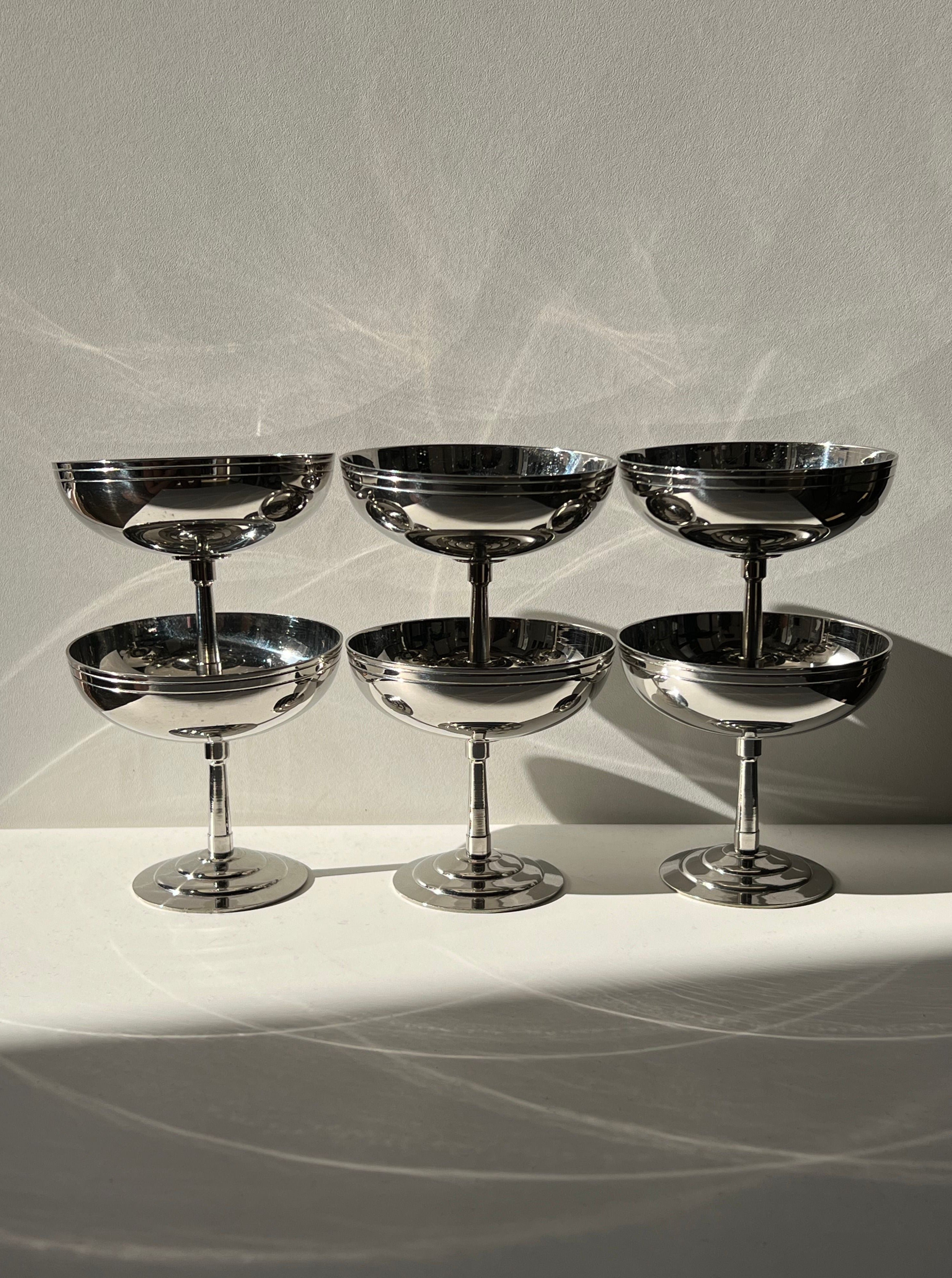 Set of 6 silver-toned coupe glasses arranged on white surface